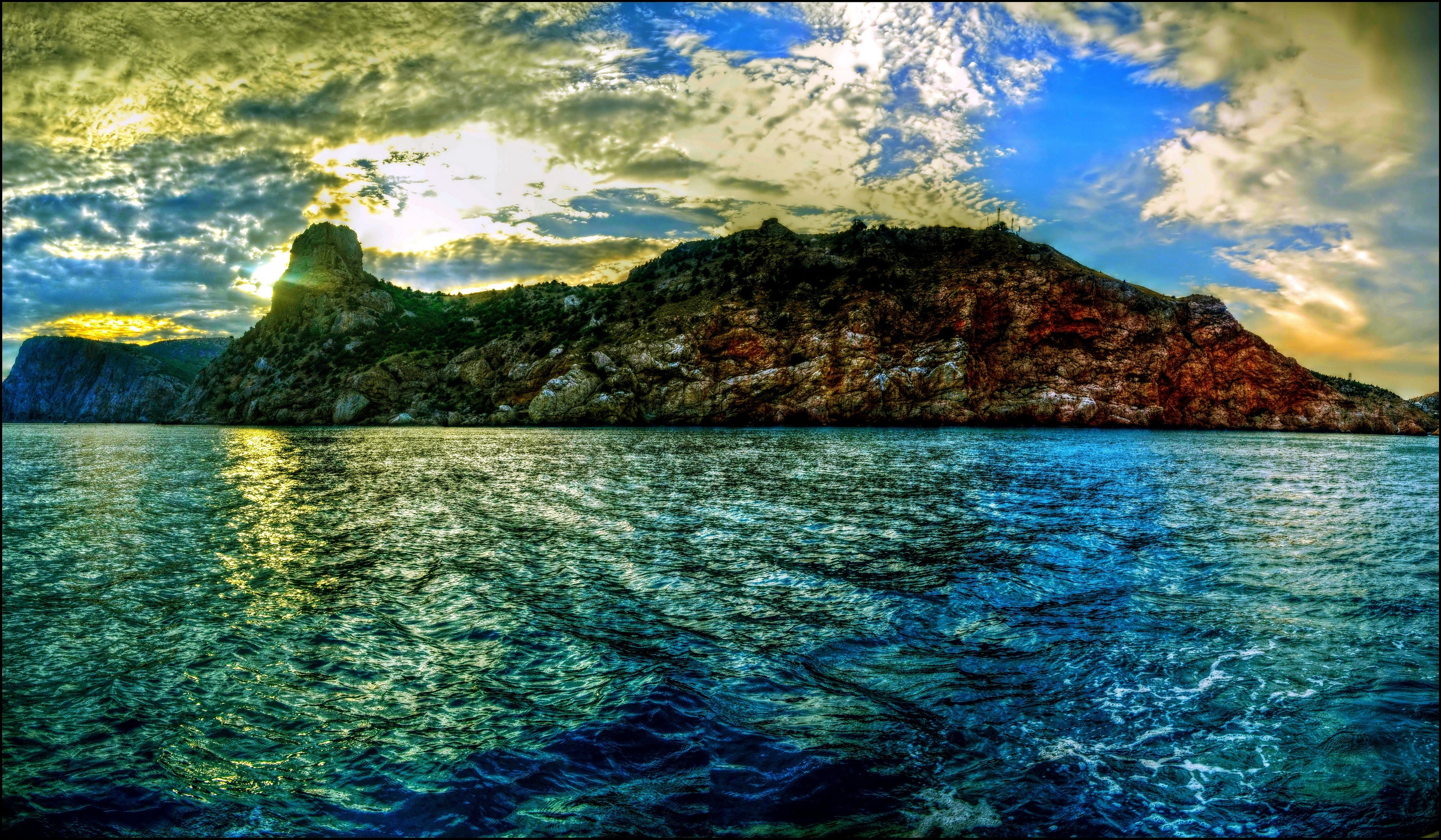 Rocky coast and sea under a cloudy sky HD Wallpaper