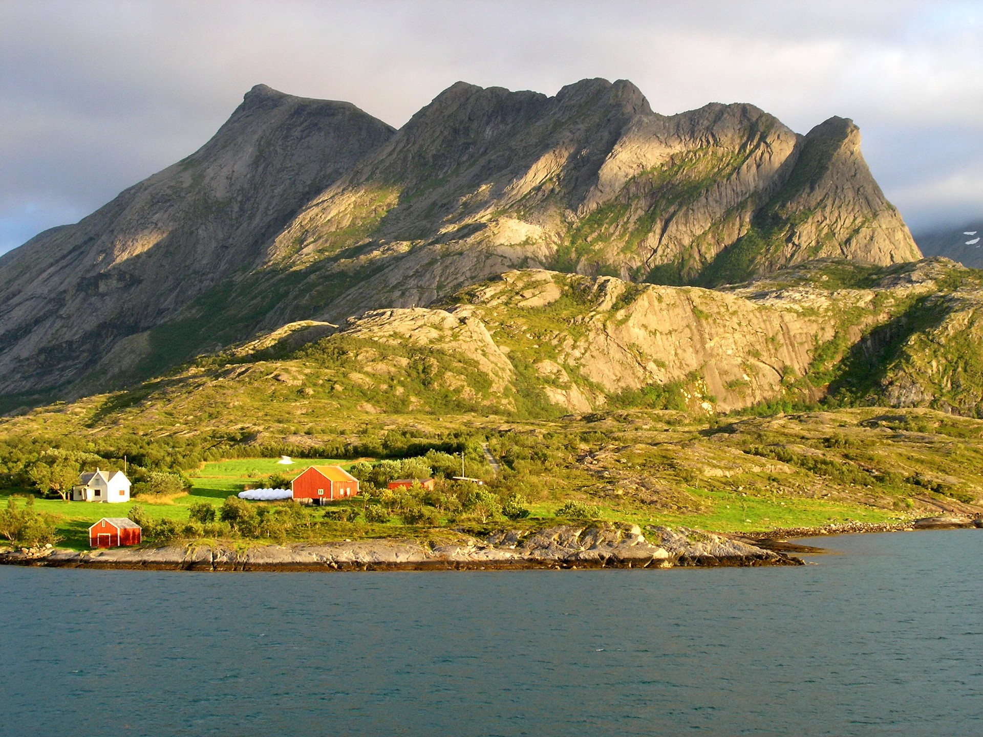 Red and white houses by a mountain and the sea HD Wallpaper