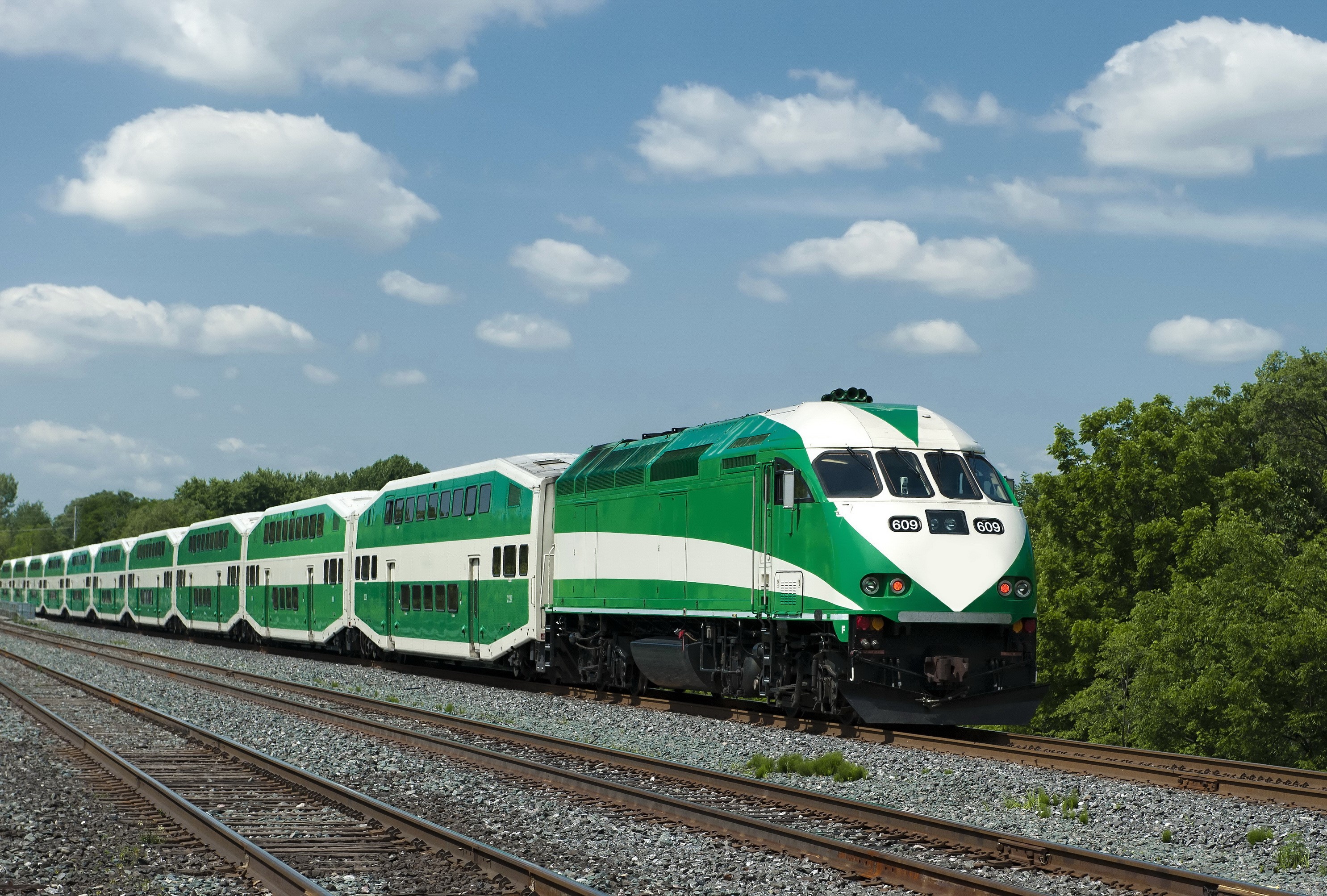 Green and white GO Transit train on railroad tracks HD Wallpaper
