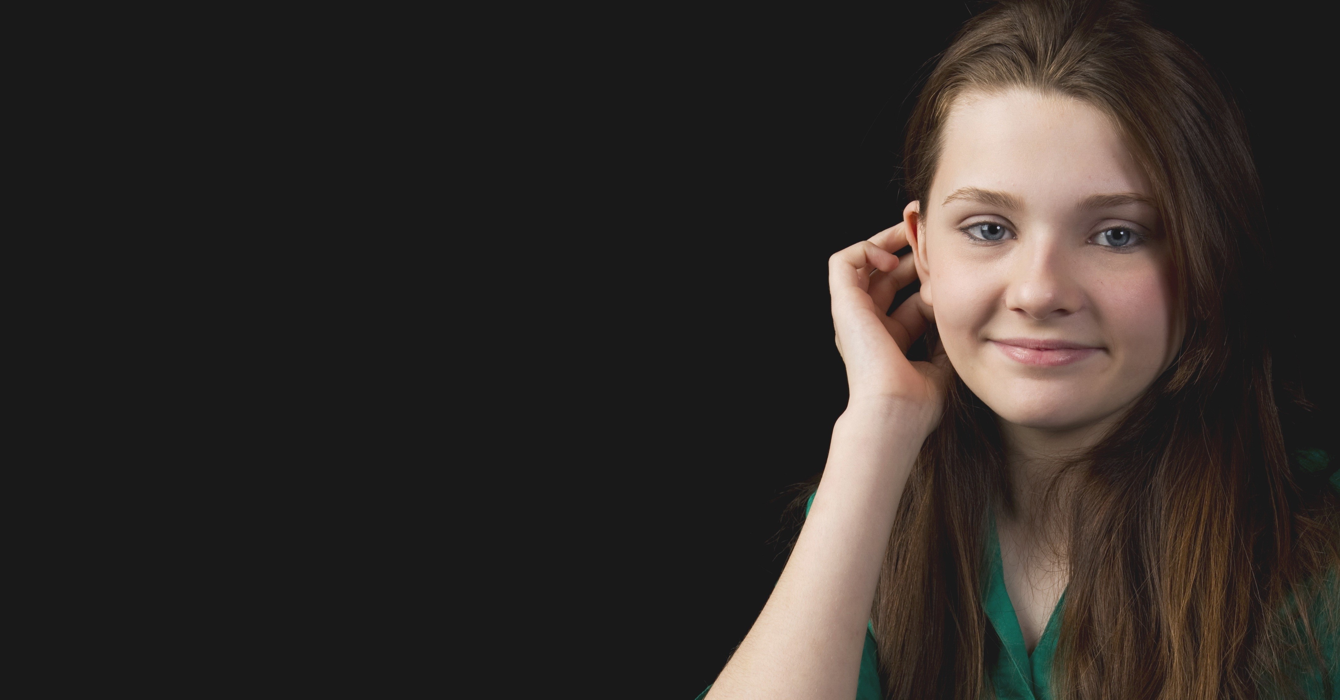 Abigail Breslin smiling with hand near ear HD Wallpaper