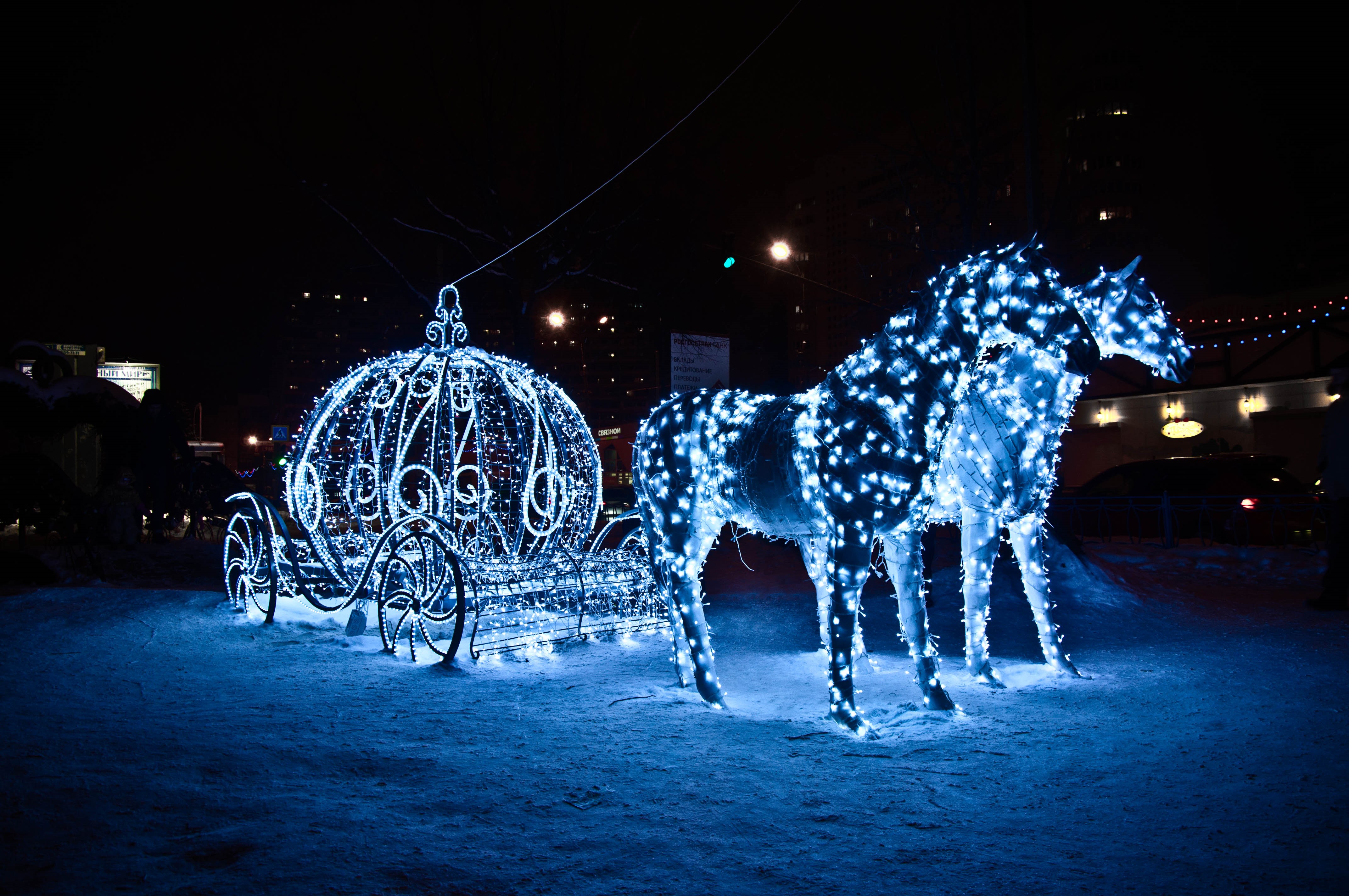 Horses and carriage decorated with fairy lights in snow at night HD Wallpaper