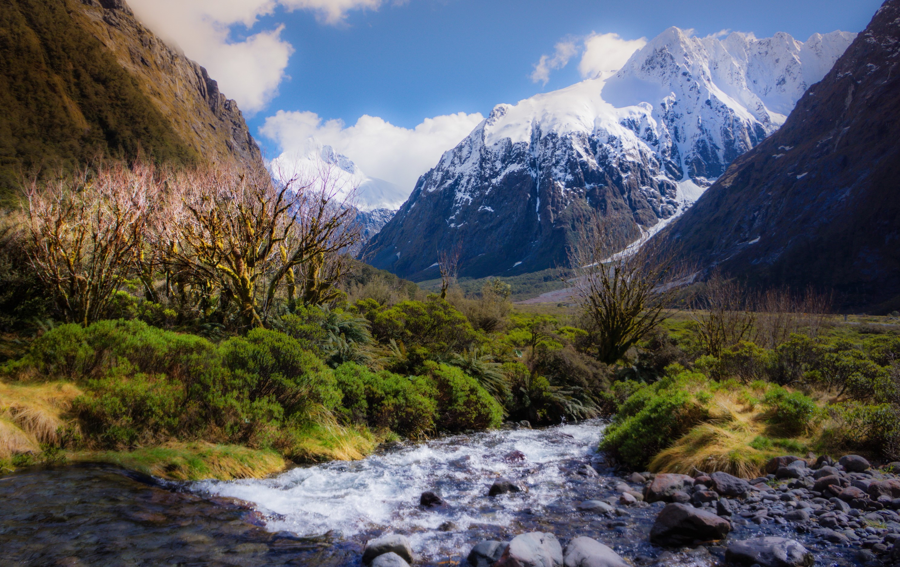 Snow-capped mountains and a river in a valley HD Wallpaper