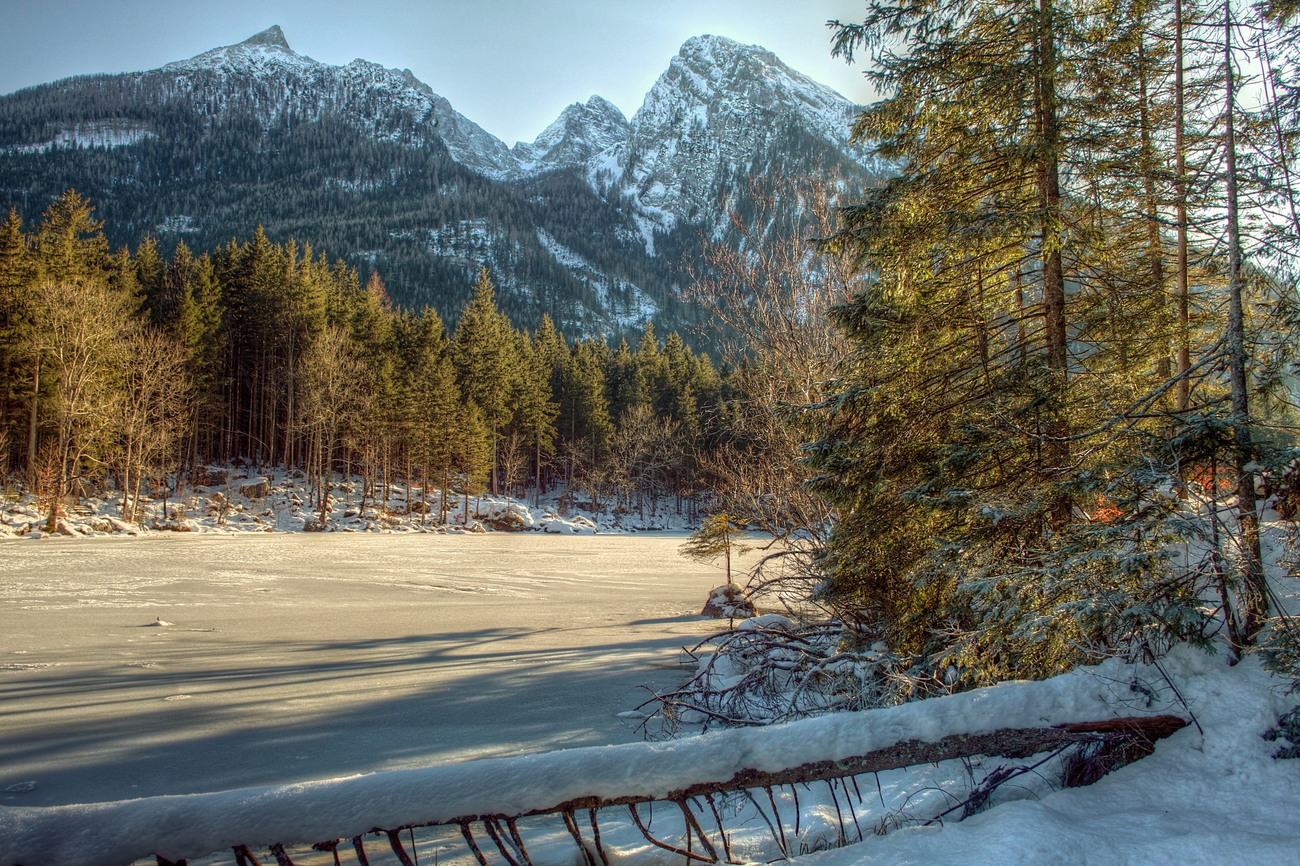 Winter scene with snow-covered mountains and frozen lake HD Wallpaper
