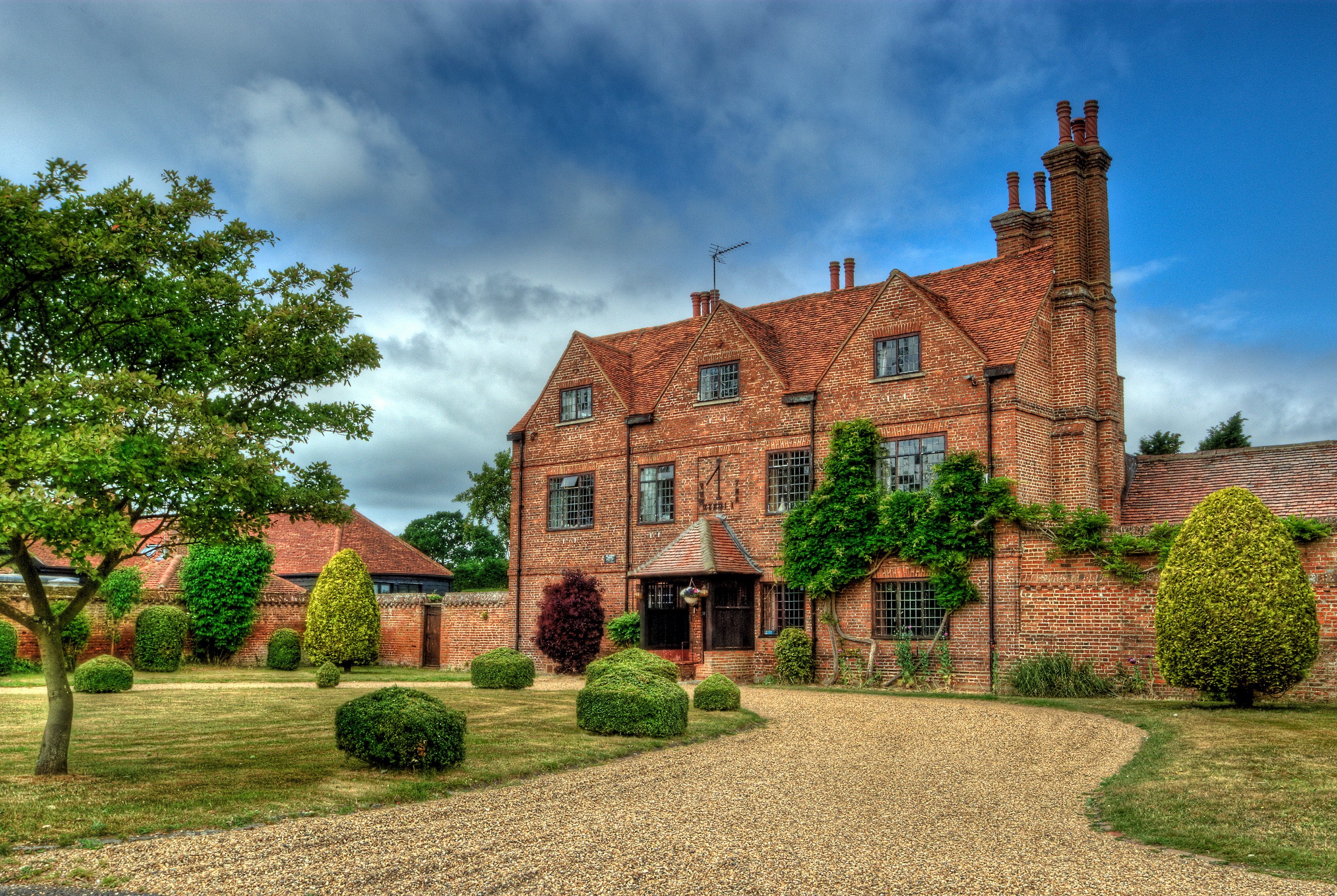 Brick house with manicured garden and trees HD Wallpaper