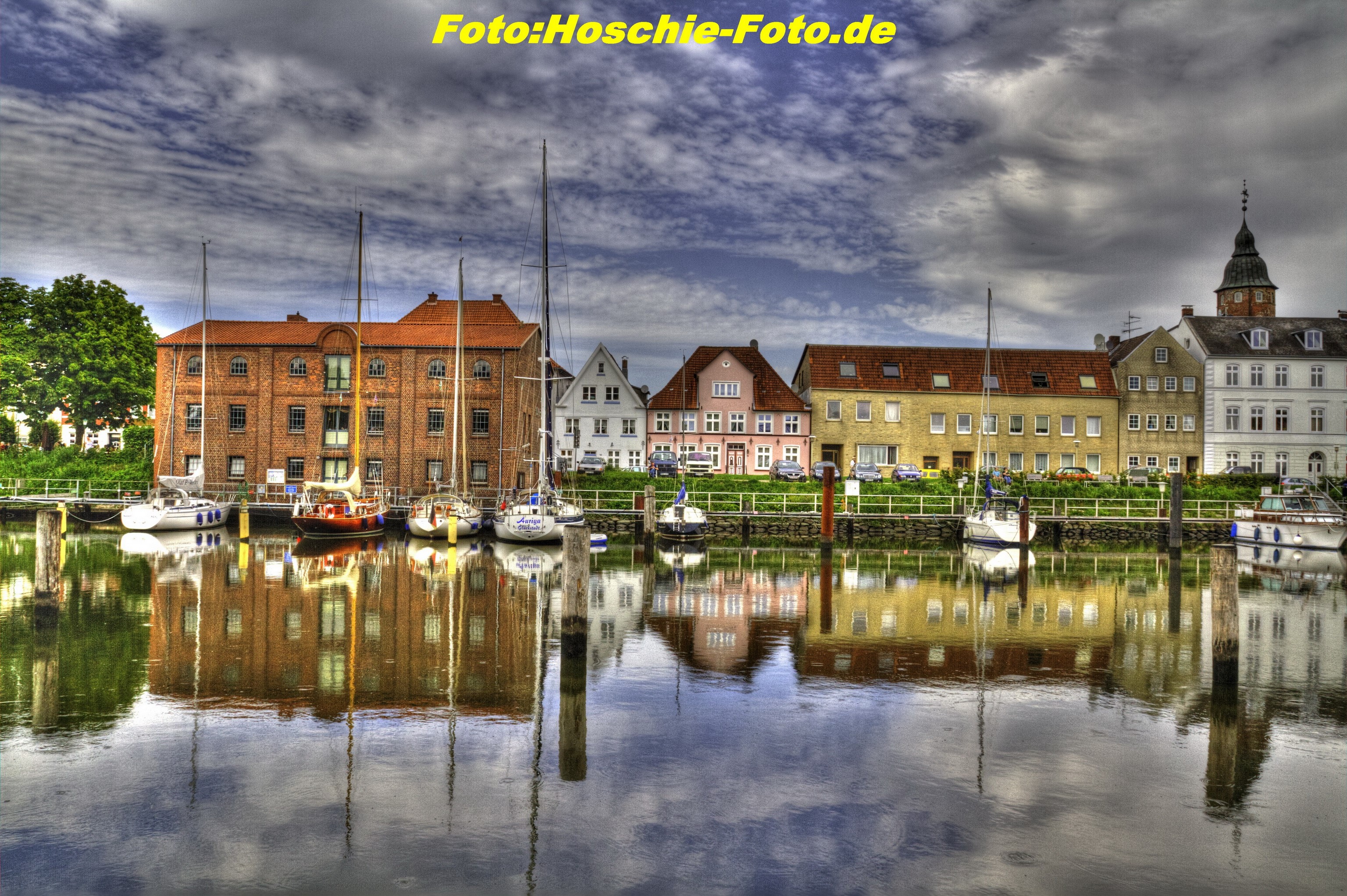 Boats docked in a German harbor with colorful buildings HD Wallpaper