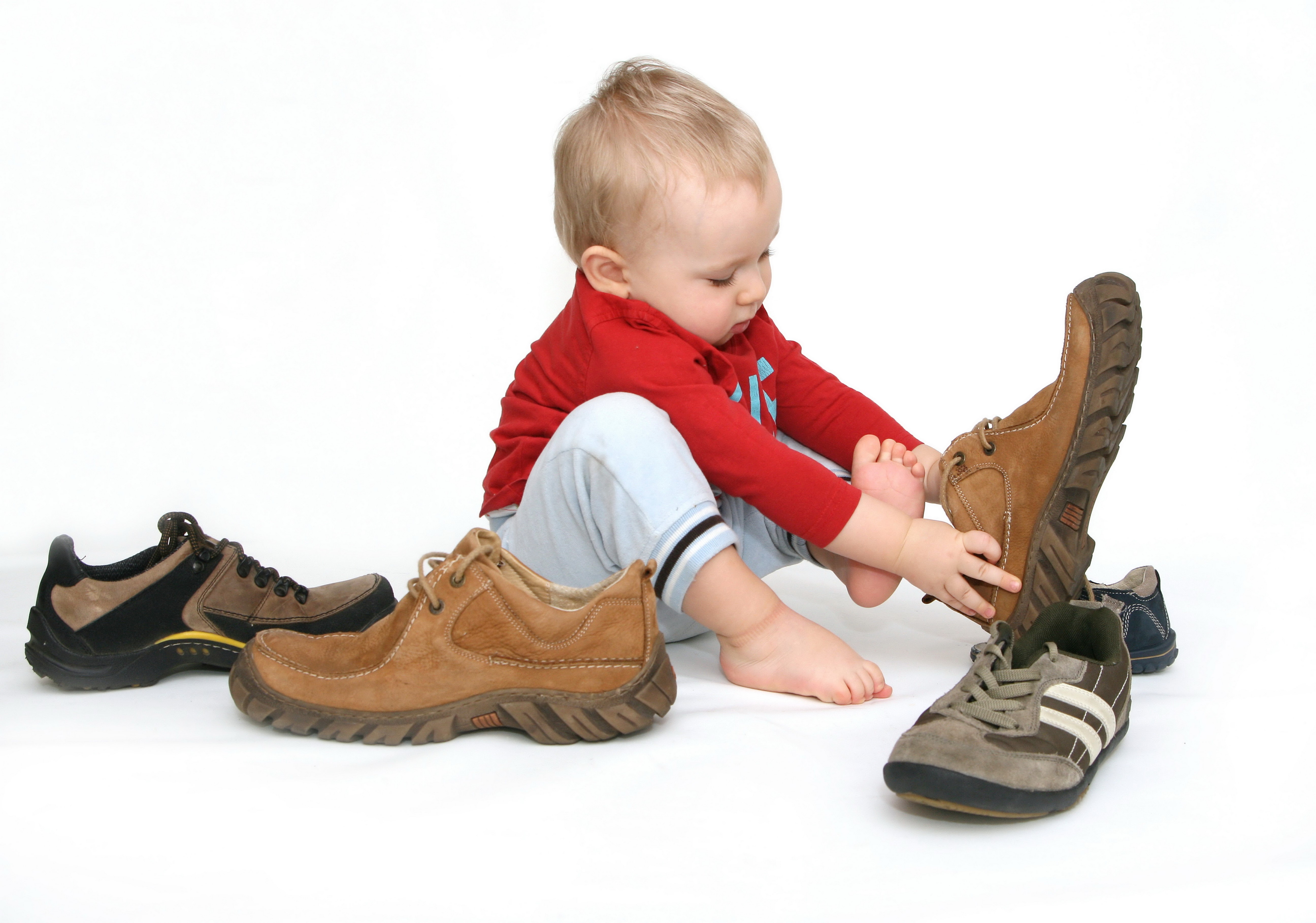 Baby trying on adult shoes HD Wallpaper