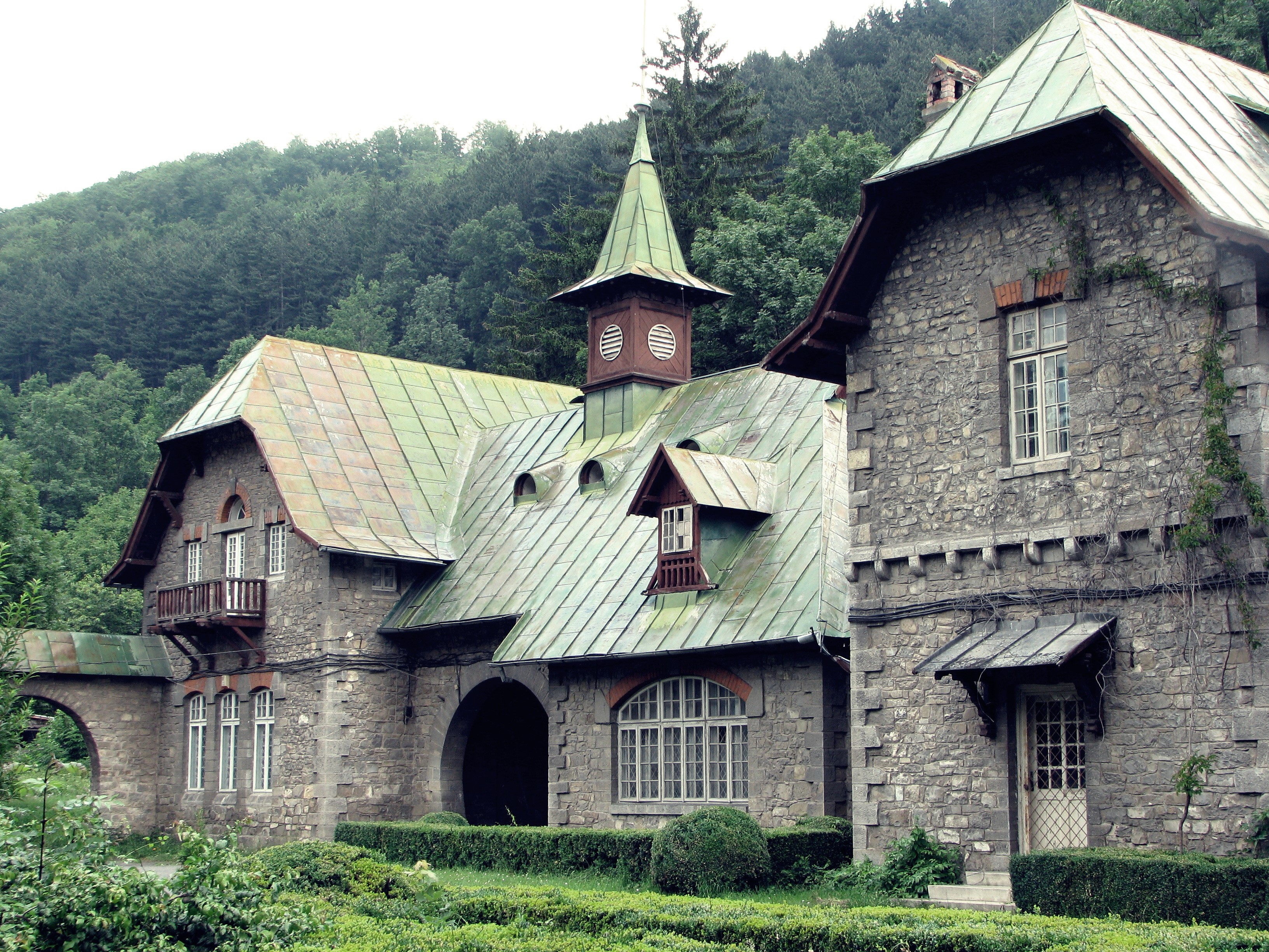 Stone mansion with green roofs and forest background HD Wallpaper