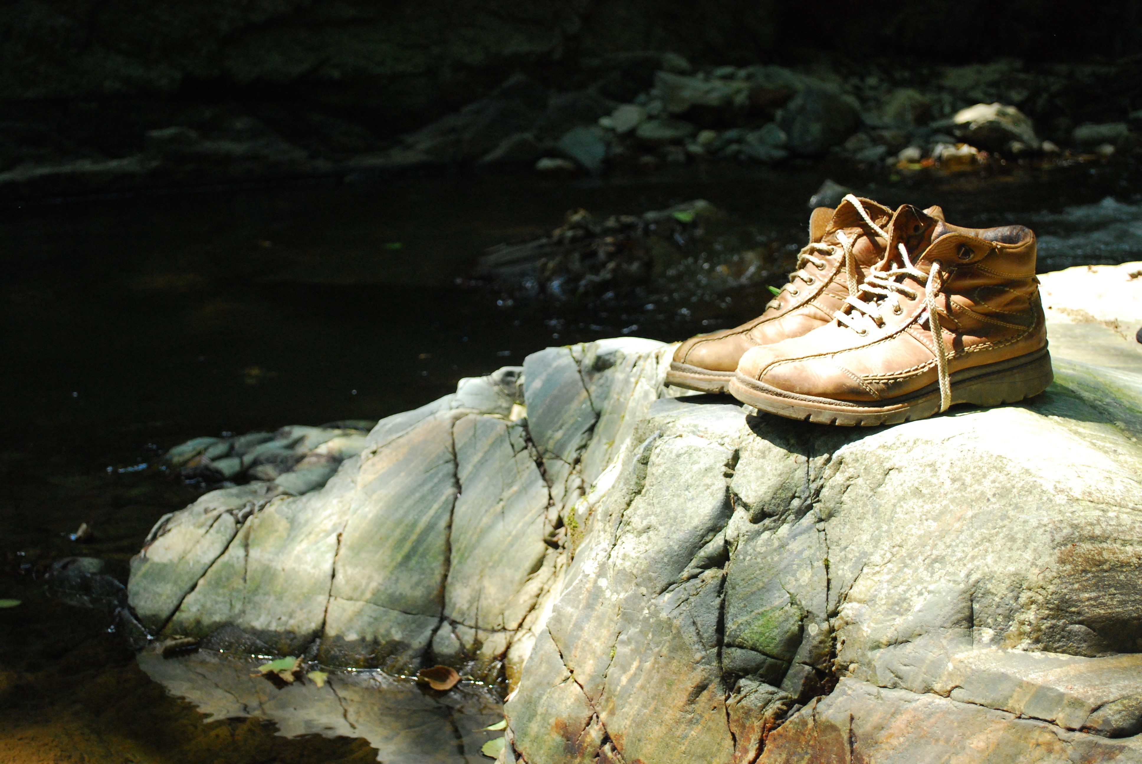 Brown Boots on Rocks by Water HD Wallpaper