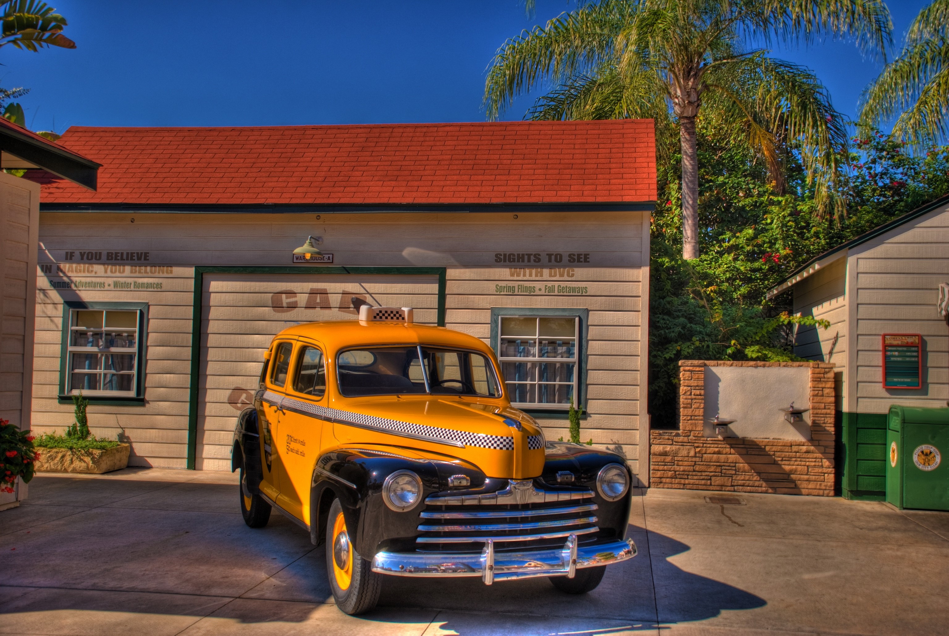 Yellow and black taxi in front of a building HD Wallpaper