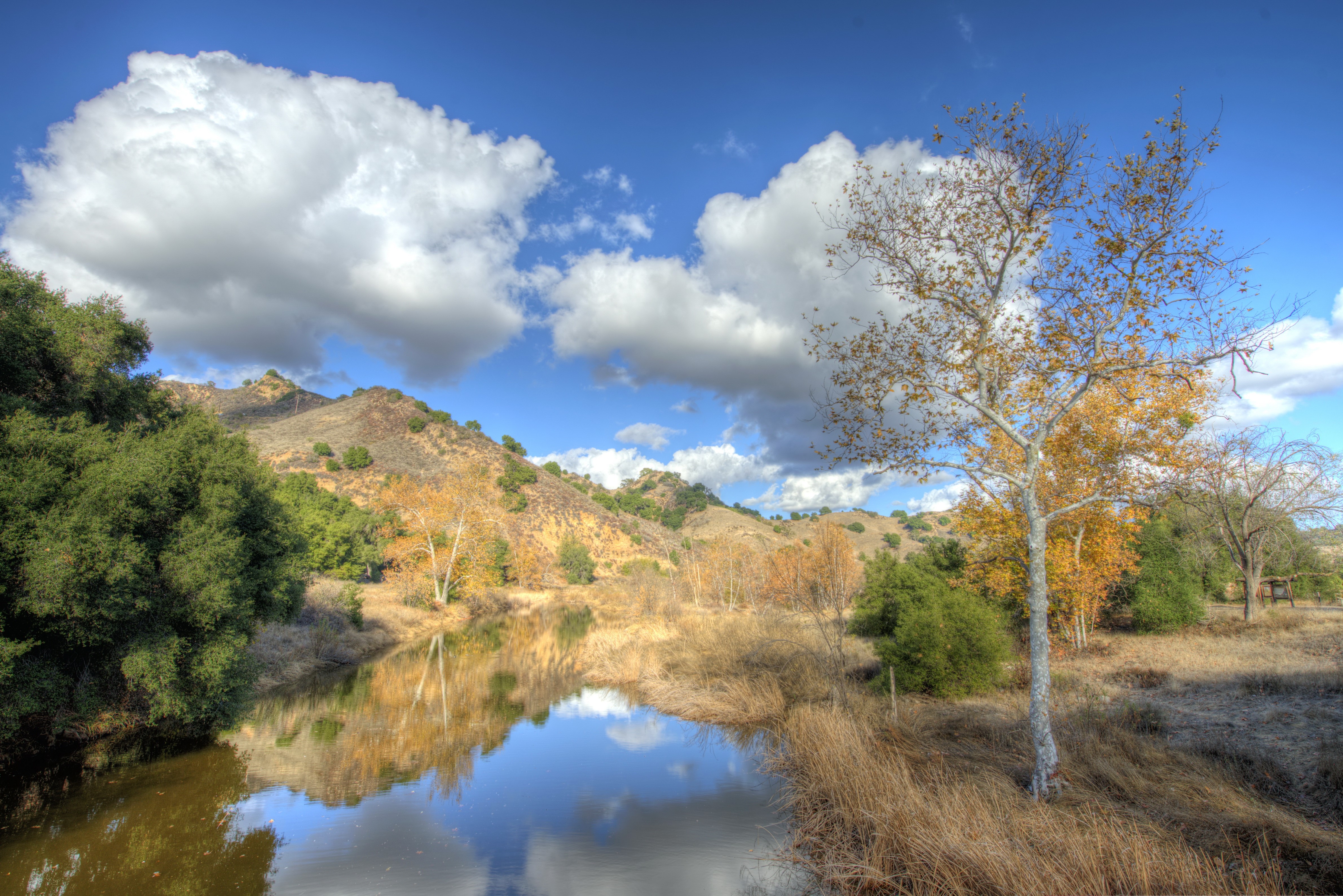 River reflecting hills and trees under a cloudy sky HD Wallpaper