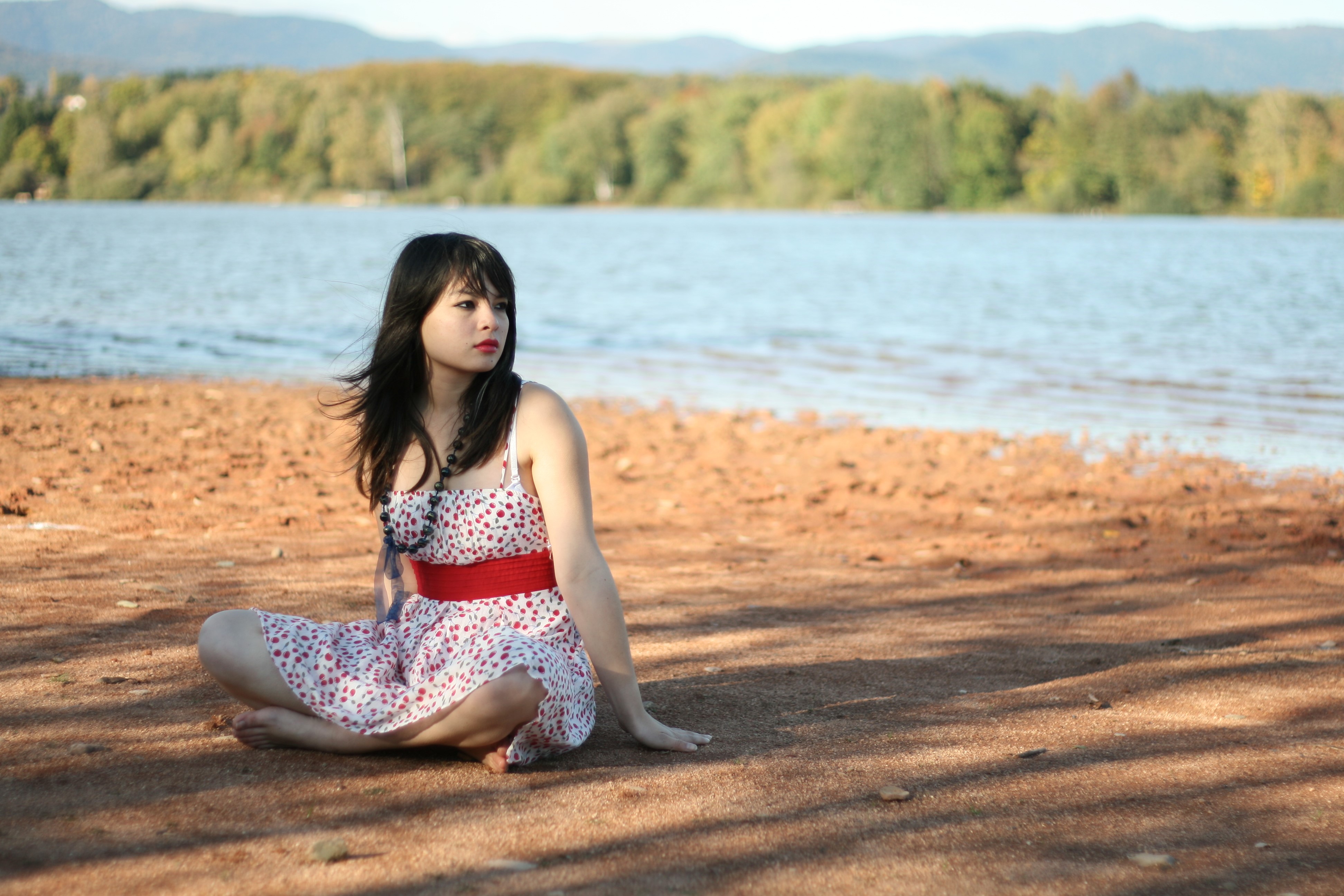 Asian girl in dress sitting by lake HD Wallpaper