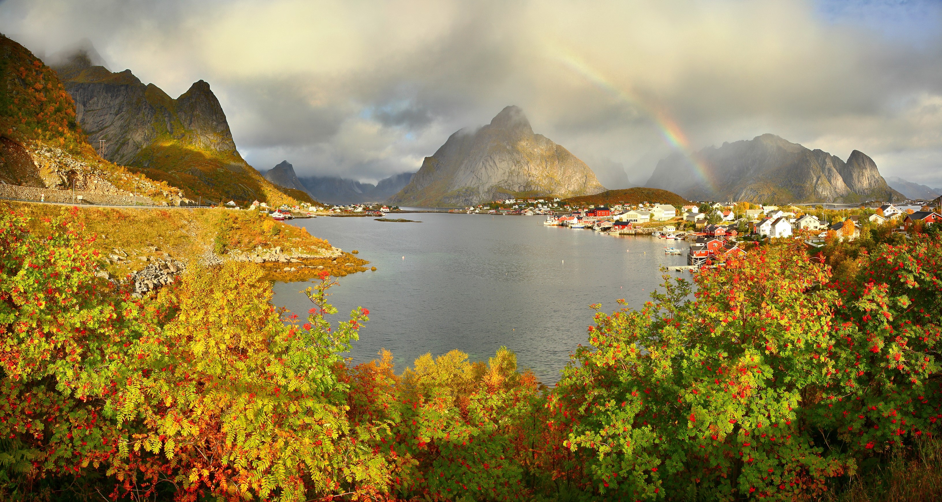 Rainbow over Reine village with mountains and autumn foliage HD Wallpaper
