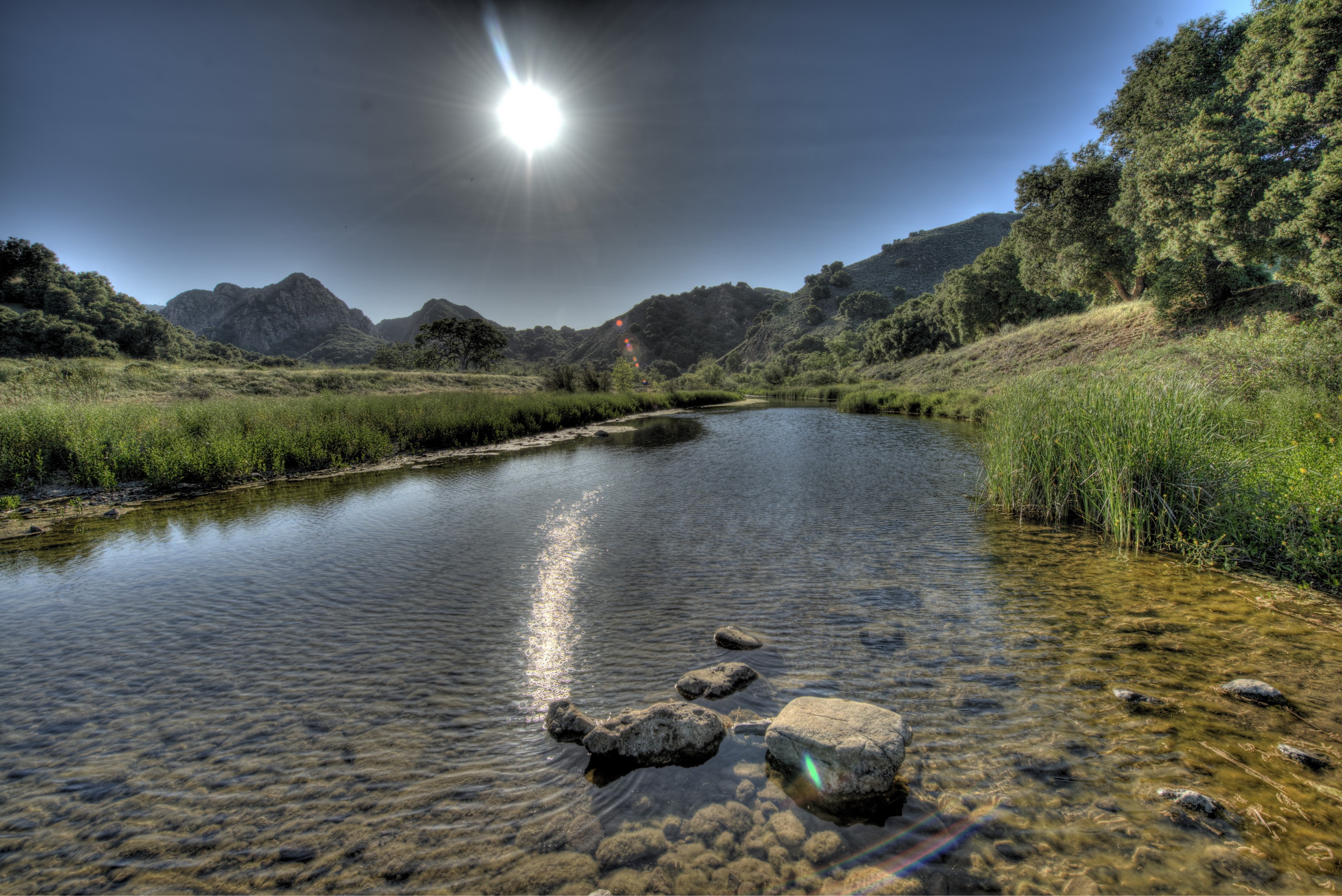River flowing through hills in Malibu, California with sun rays HD Wallpaper