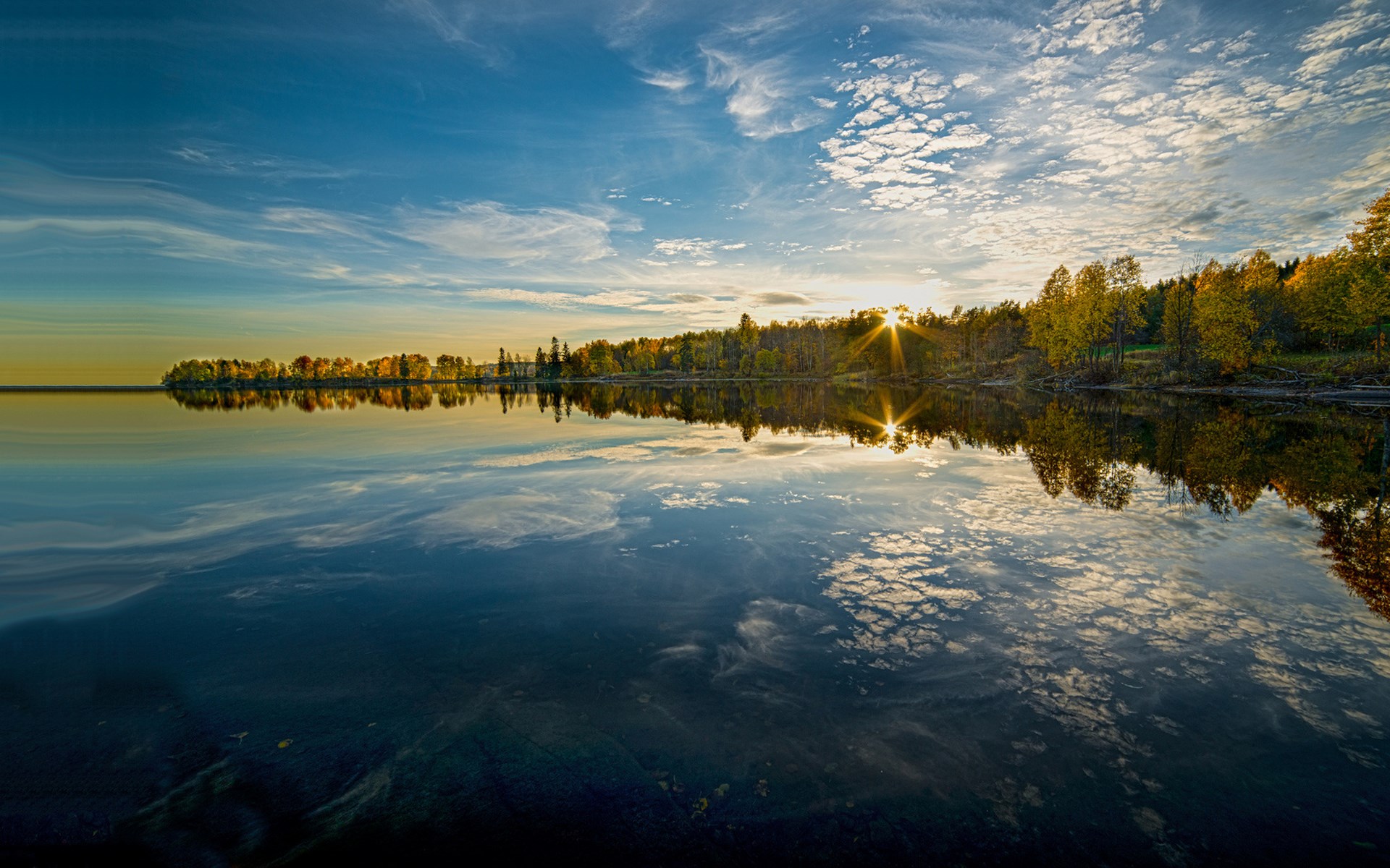 Sunset over a calm lake with autumn trees reflected HD Wallpaper
