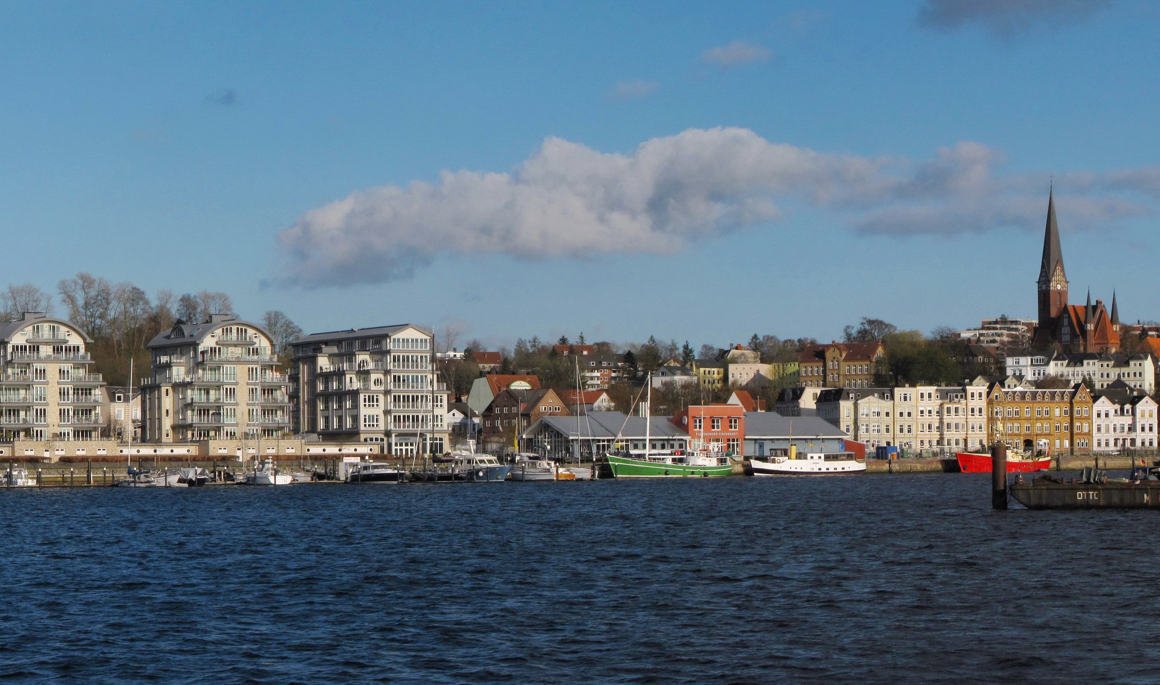 Waterfront cityscape with modern buildings and a church spire HD Wallpaper
