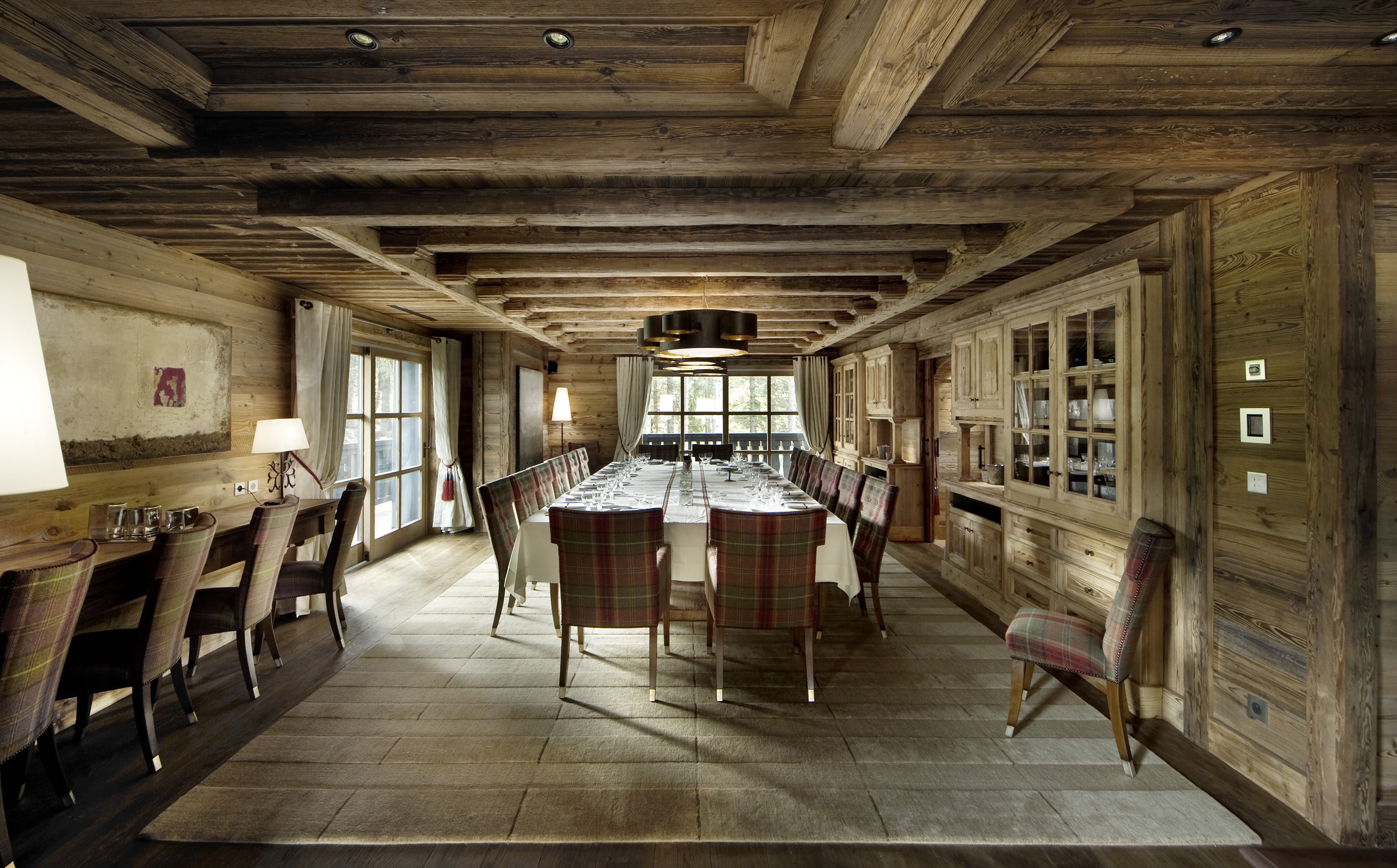 Rustic wooden dining room with long table and plaid chairs HD Wallpaper