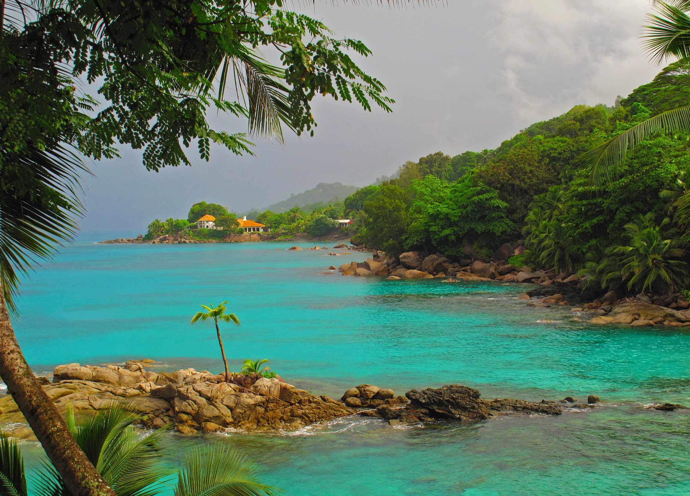 Tropical island with turquoise water and lush green hills HD Wallpaper