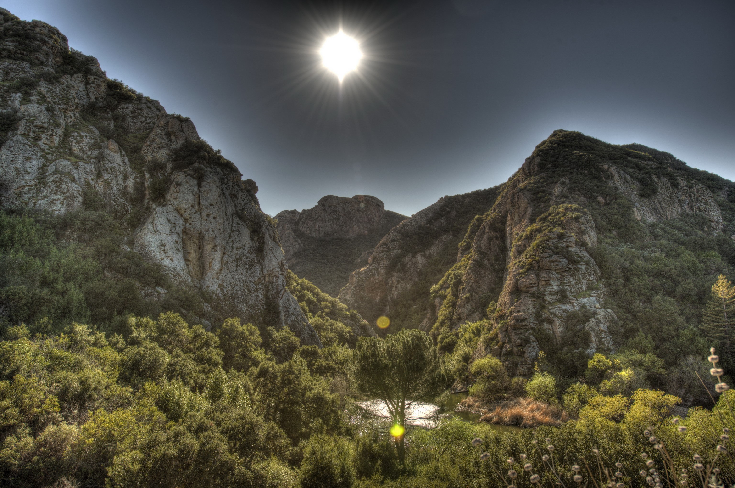 Sunlight shining over mountains and trees in Malibu, California HD Wallpaper