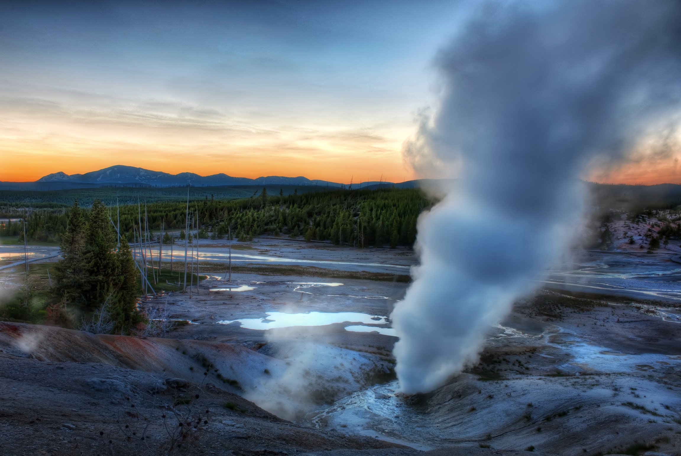 Steam erupting from geyser in Yellowstone National Park at sunset HD Wallpaper