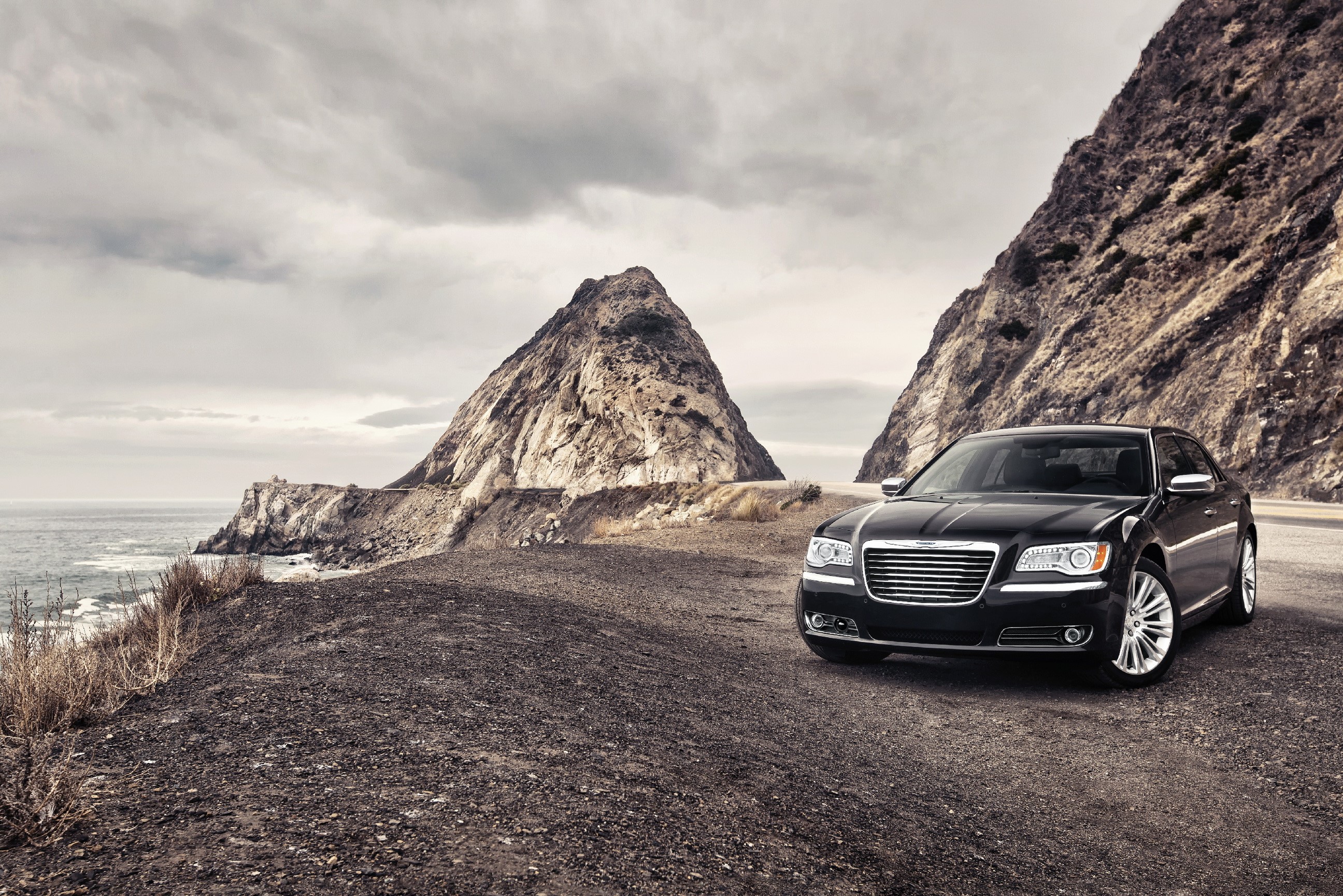 Black Chrysler 300 parked on a coastal road HD Wallpaper