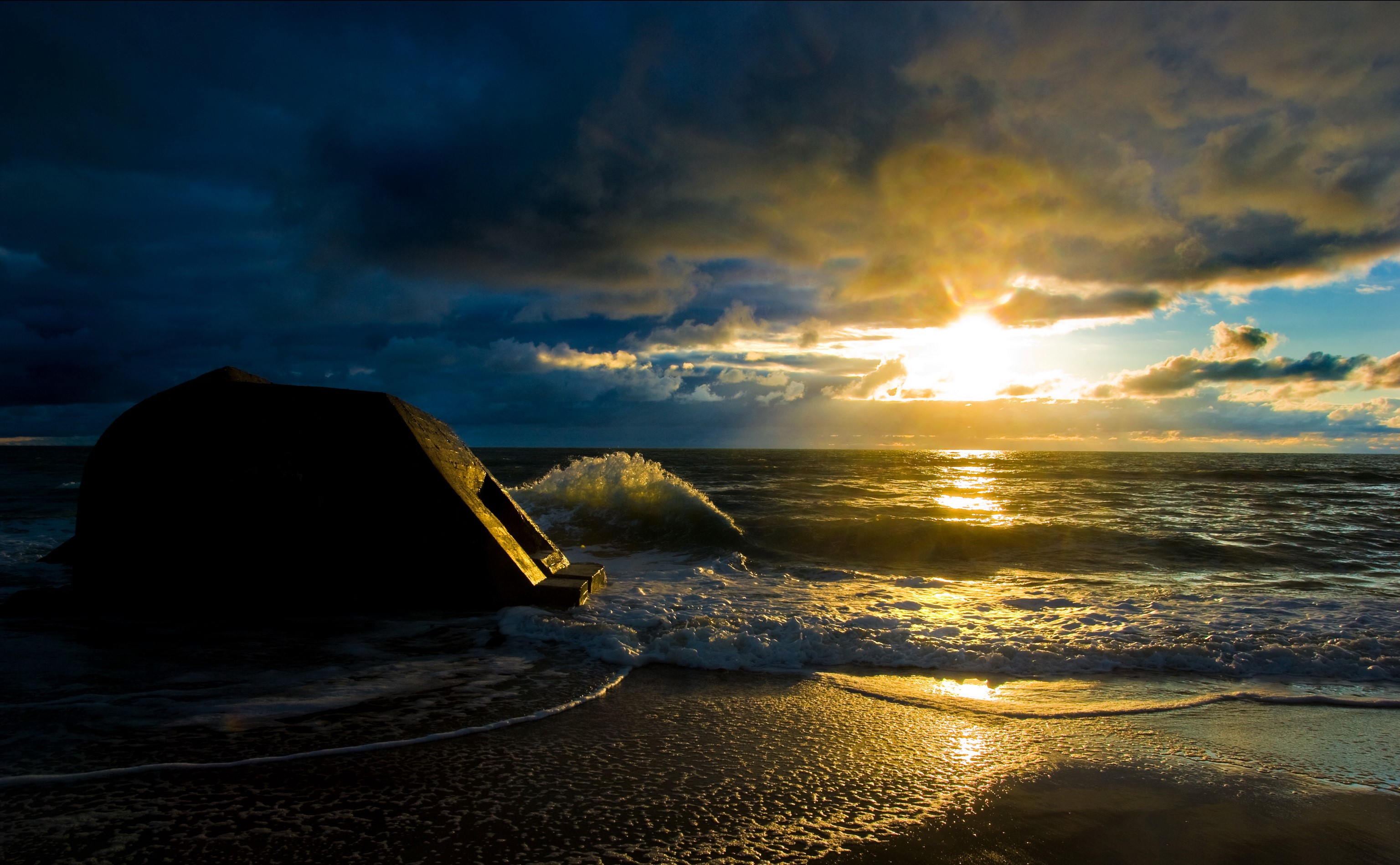 Concrete structure on a beach at sunset HD Wallpaper
