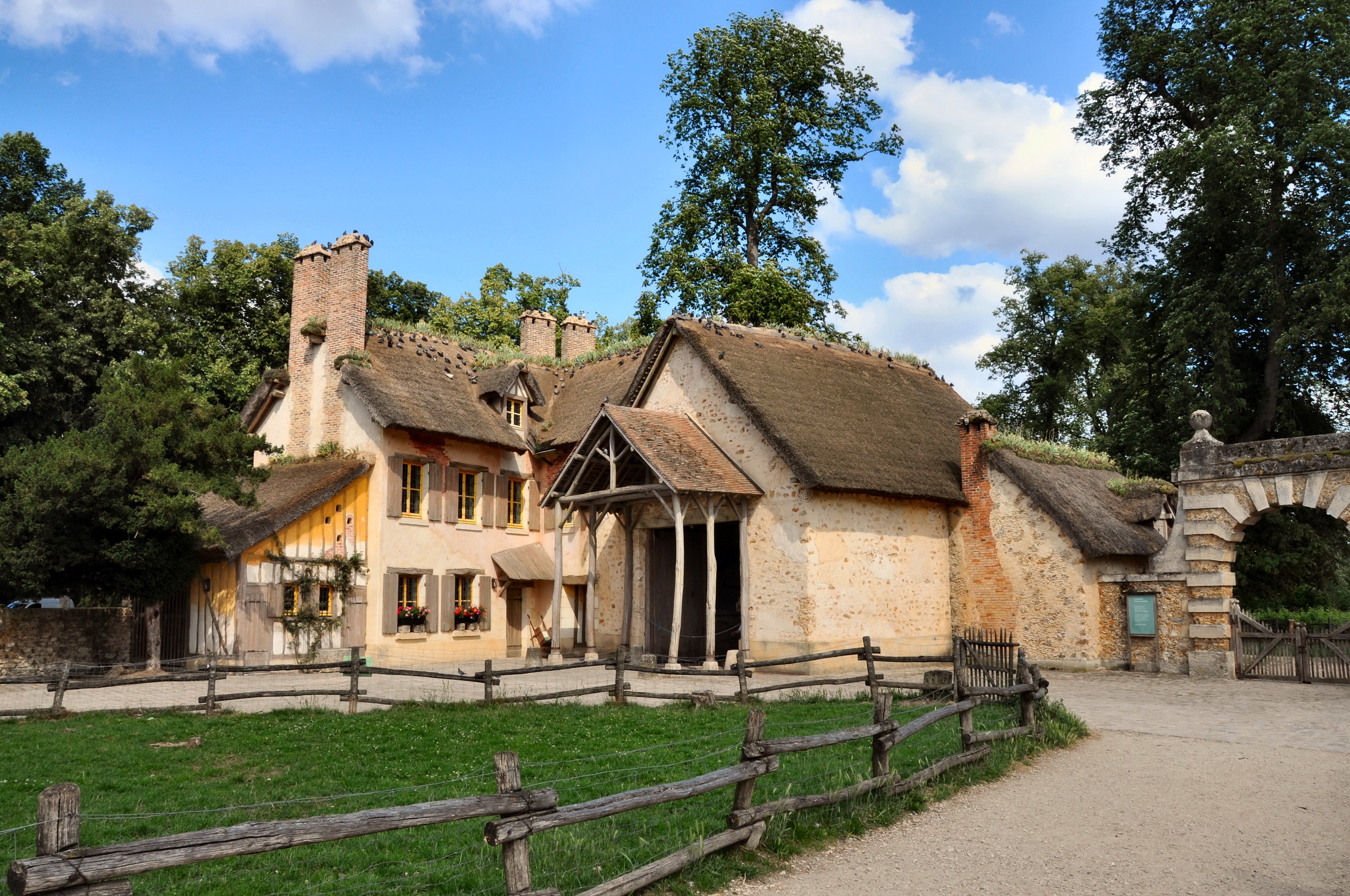 Thatched-roof houses with stone archway in France HD Wallpaper