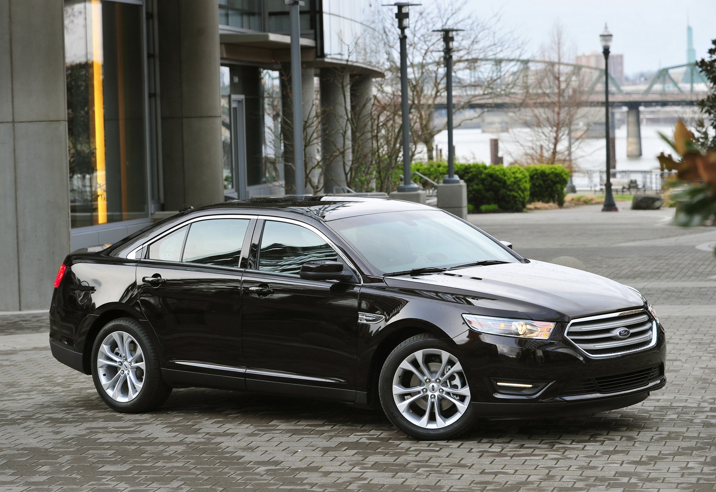 Black 2013 Ford Taurus parked on a brick patio HD Wallpaper