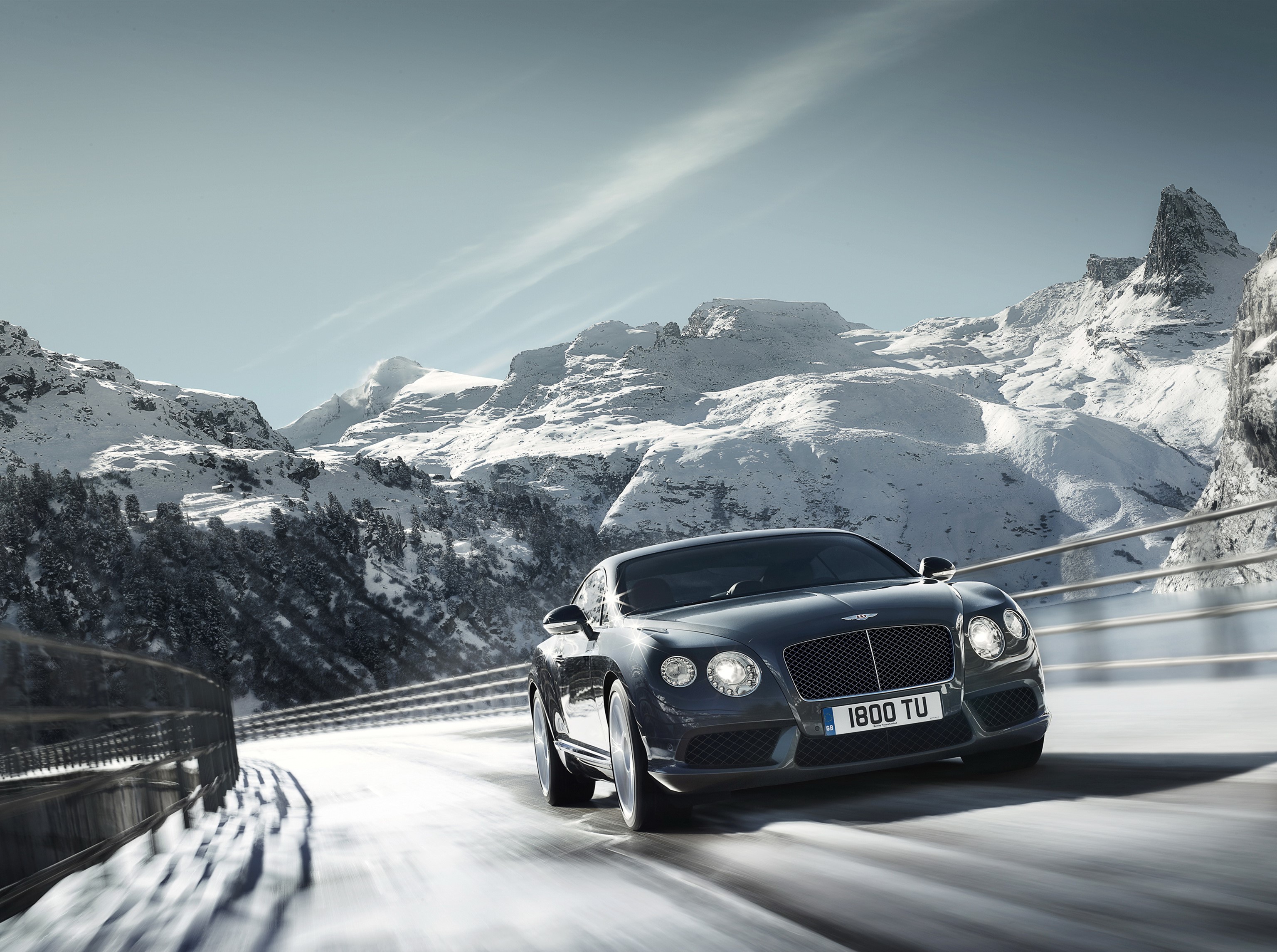 Bentley Continental GT V8 driving on a snowy mountain road HD Wallpaper