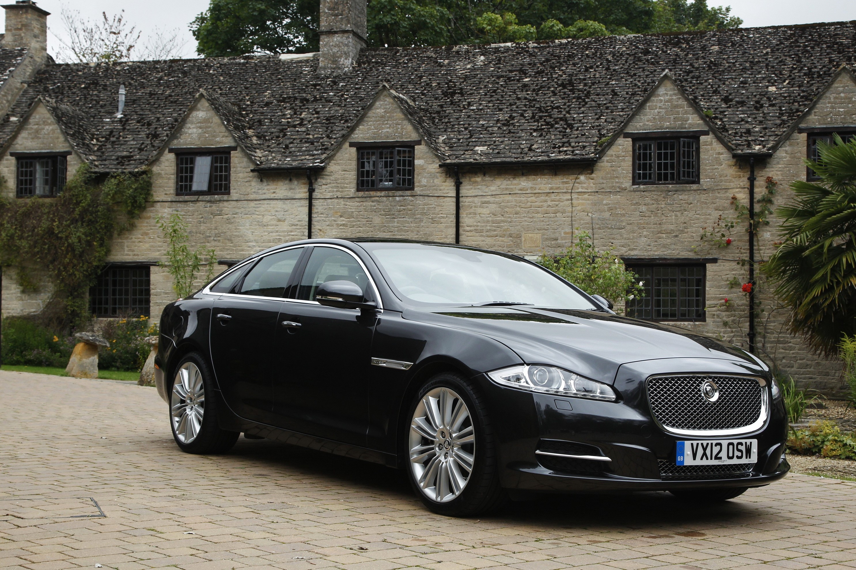 Black 2012 Jaguar XJ parked in front of a stone building HD Wallpaper