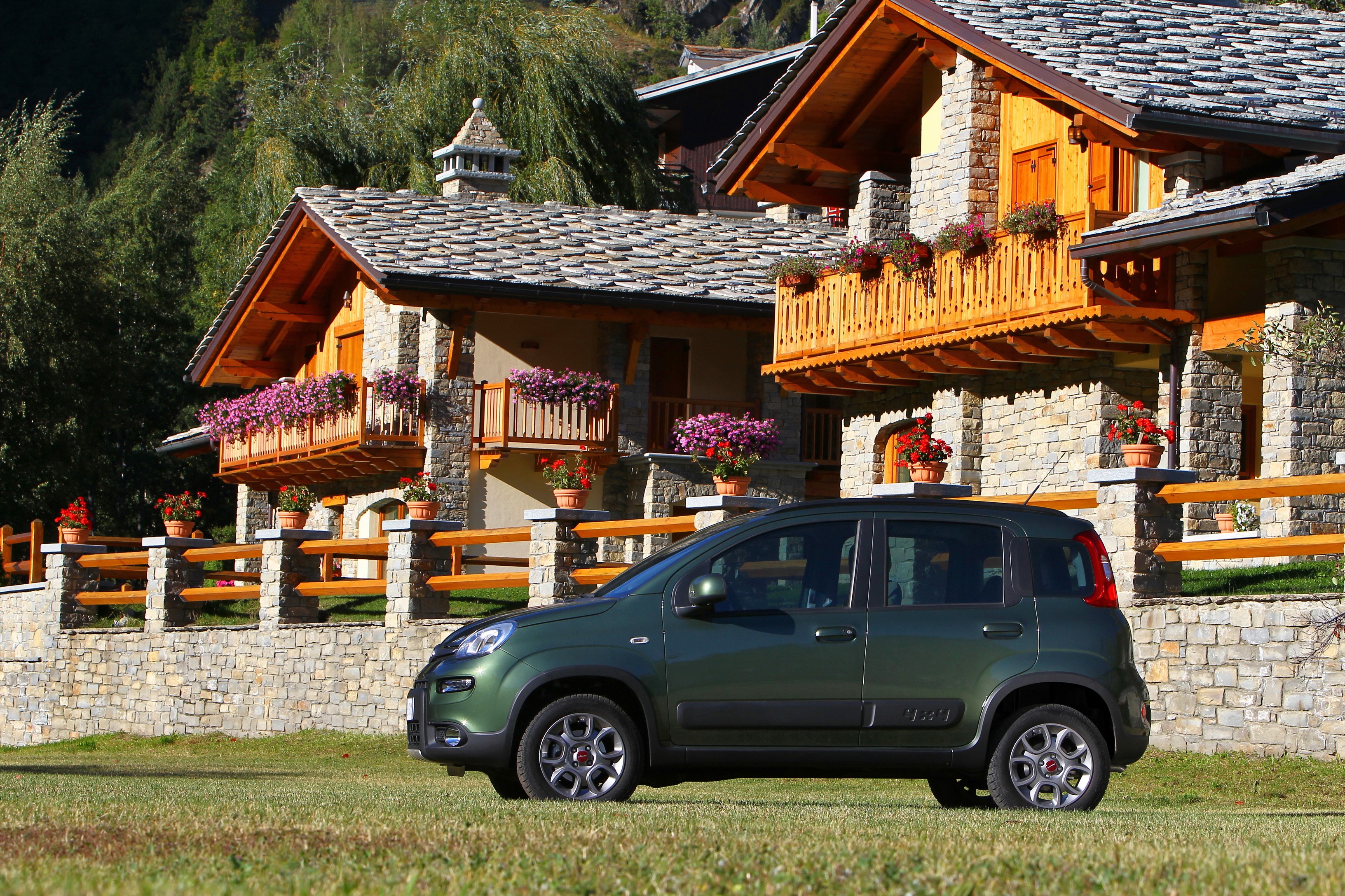 Green Fiat Panda 4x4 parked on grass in front of stone houses HD Wallpaper