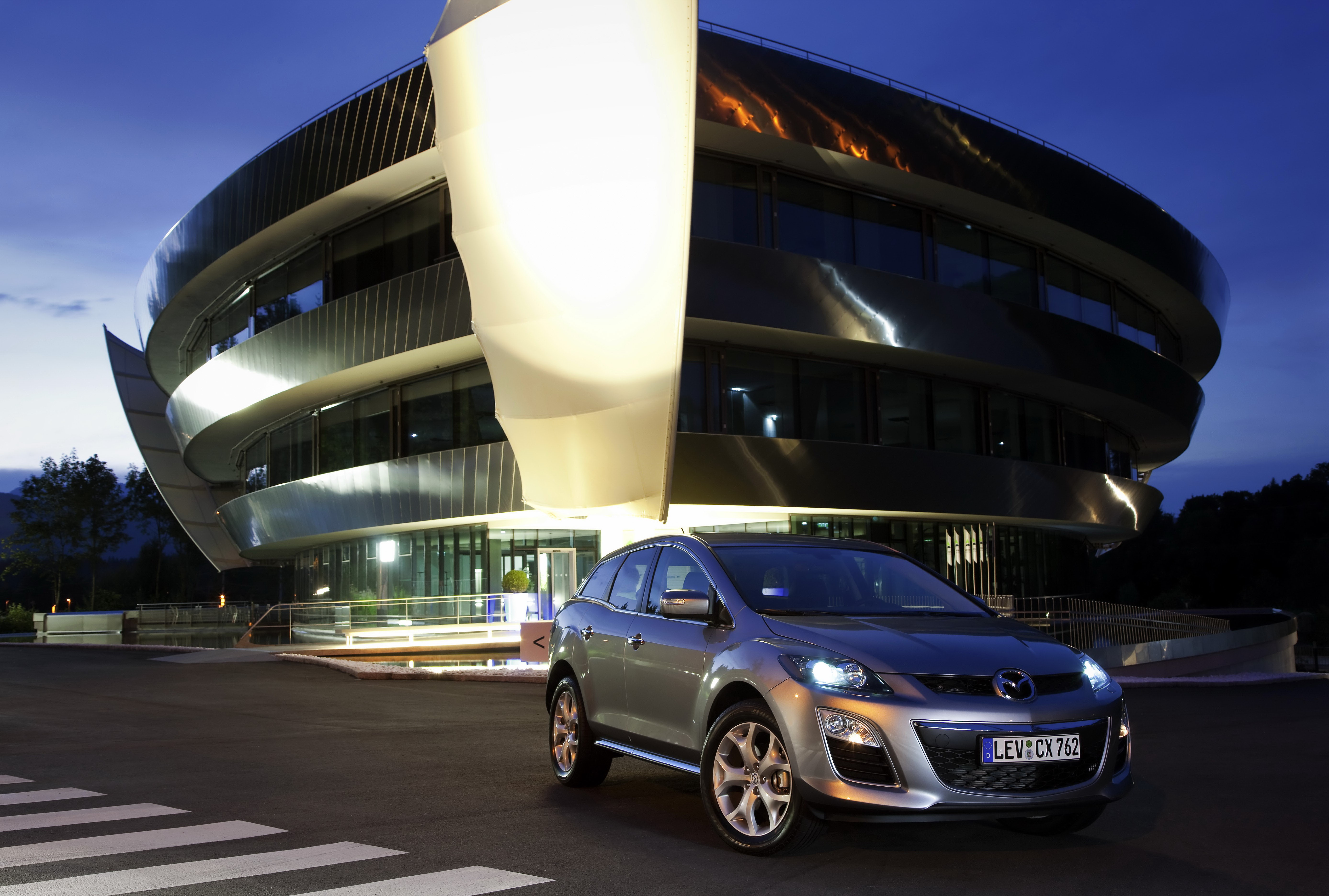 2010 Mazda CX-7 in front of a modern building HD Wallpaper