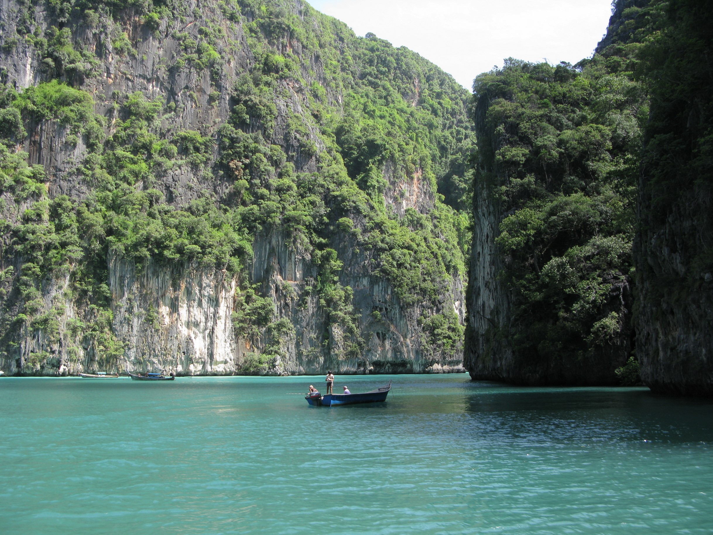 Boats in a tropical bay with limestone cliffs HD Wallpaper