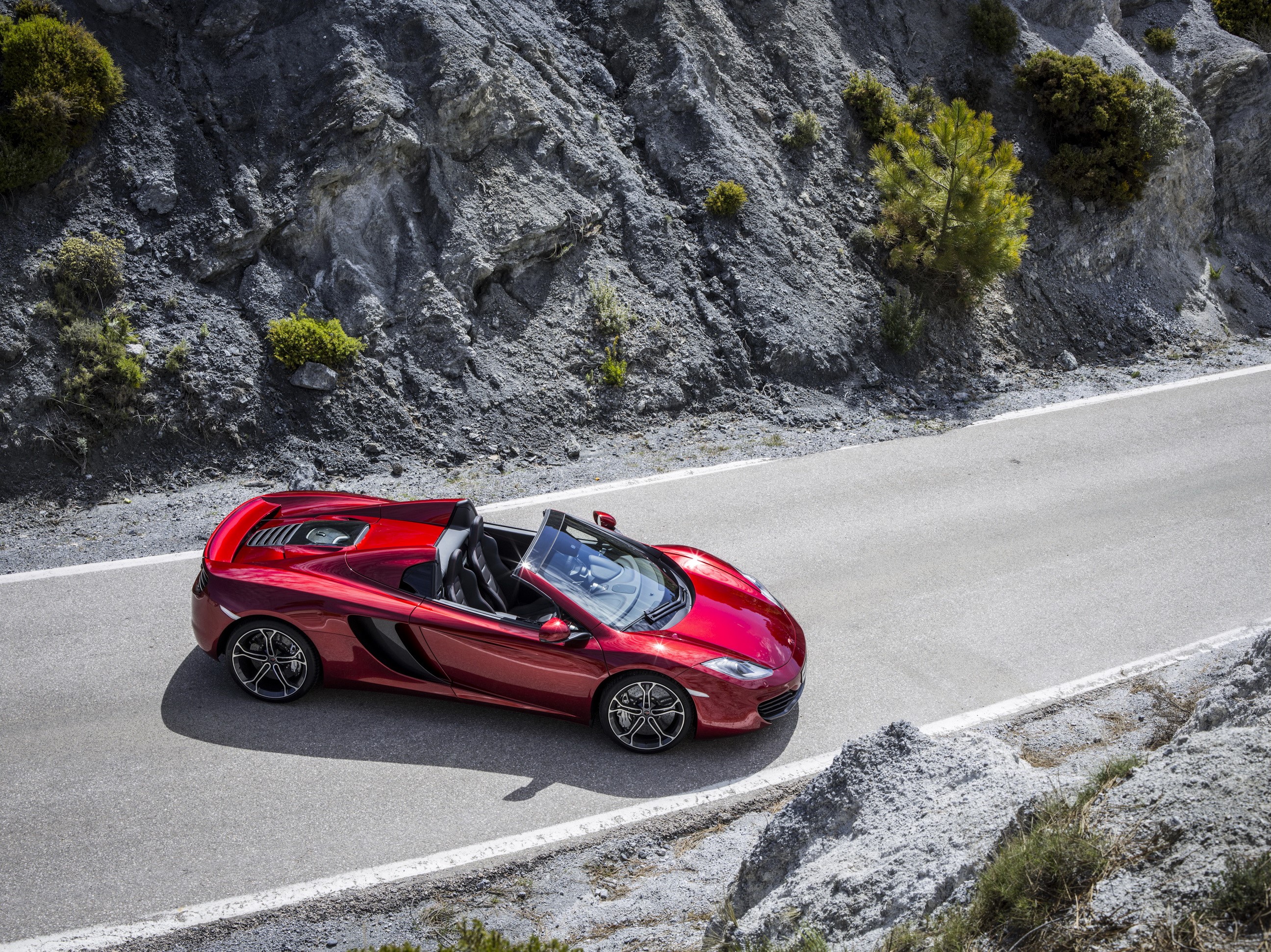 Red McLaren MP4-12C Spider driving on a mountain road HD Wallpaper