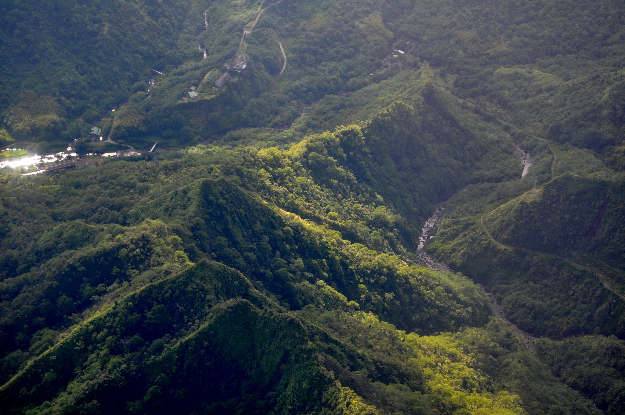 Aerial view of a lush green valley with a river HD Wallpaper