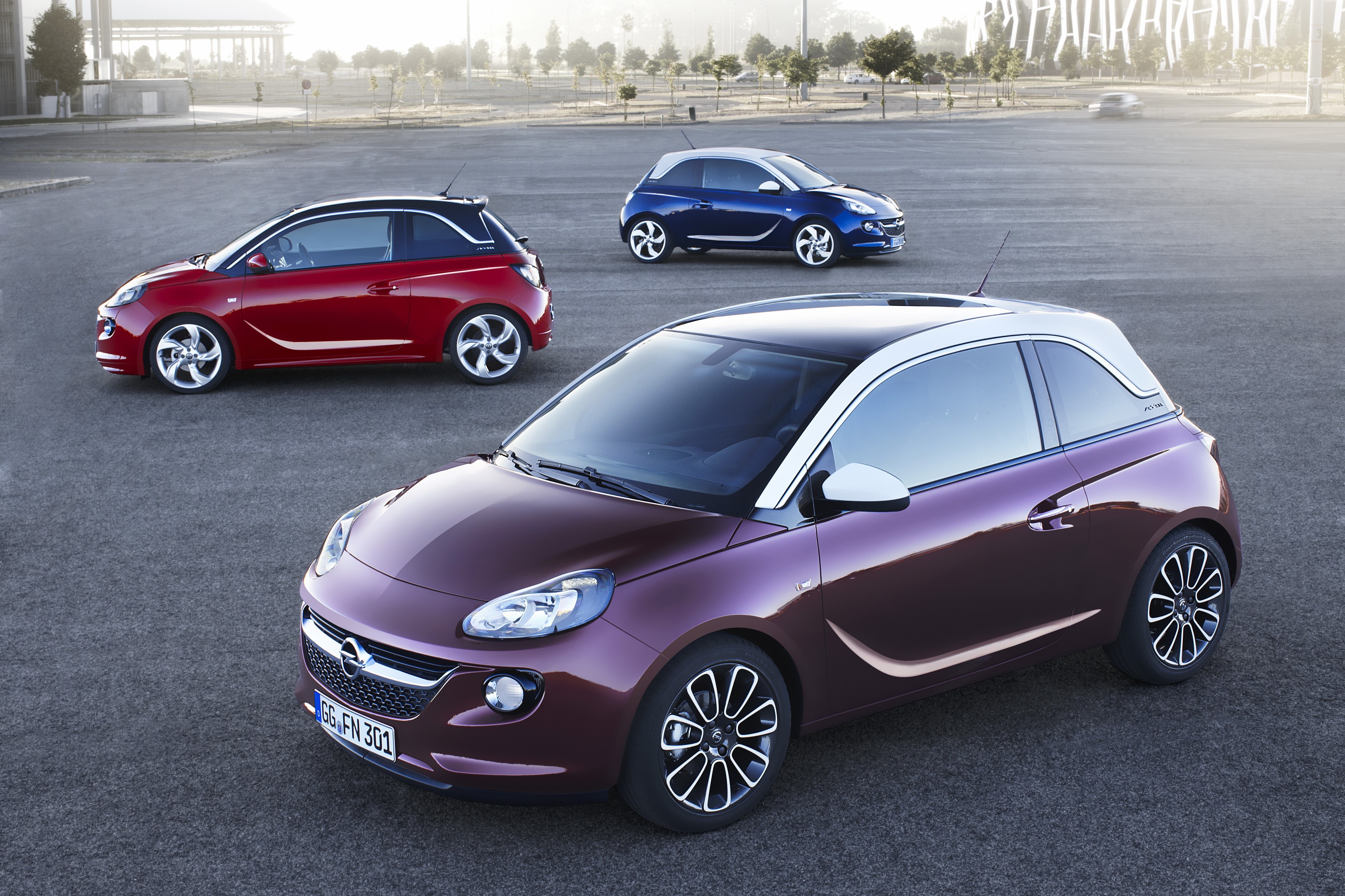 Three Opel Adam cars in a parking lot HD Wallpaper