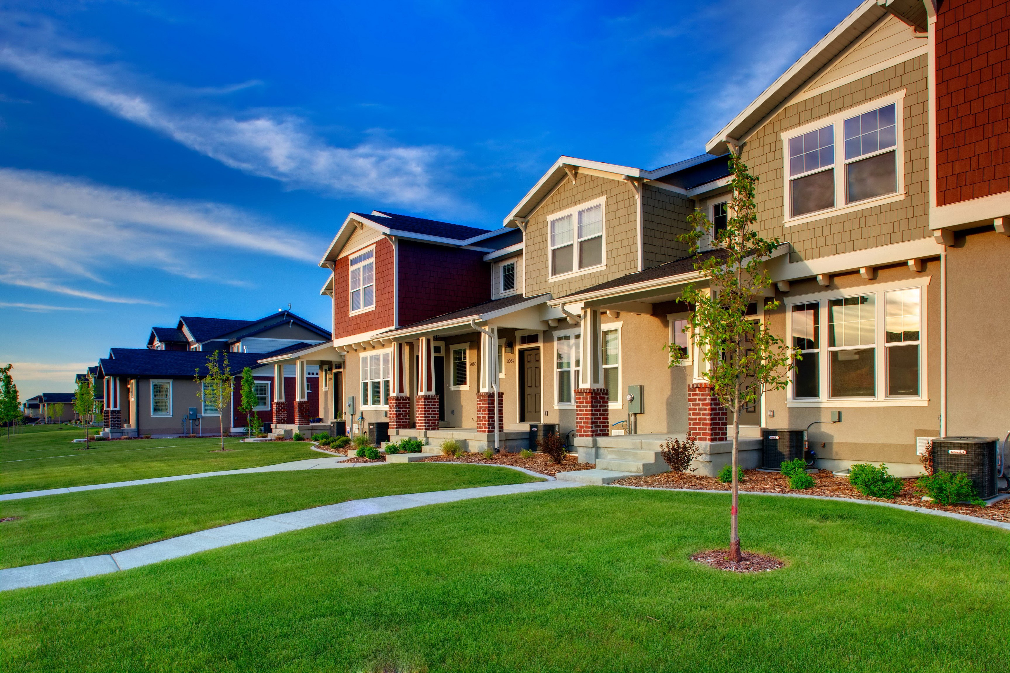 Row of modern townhouses with green lawns HD Wallpaper
