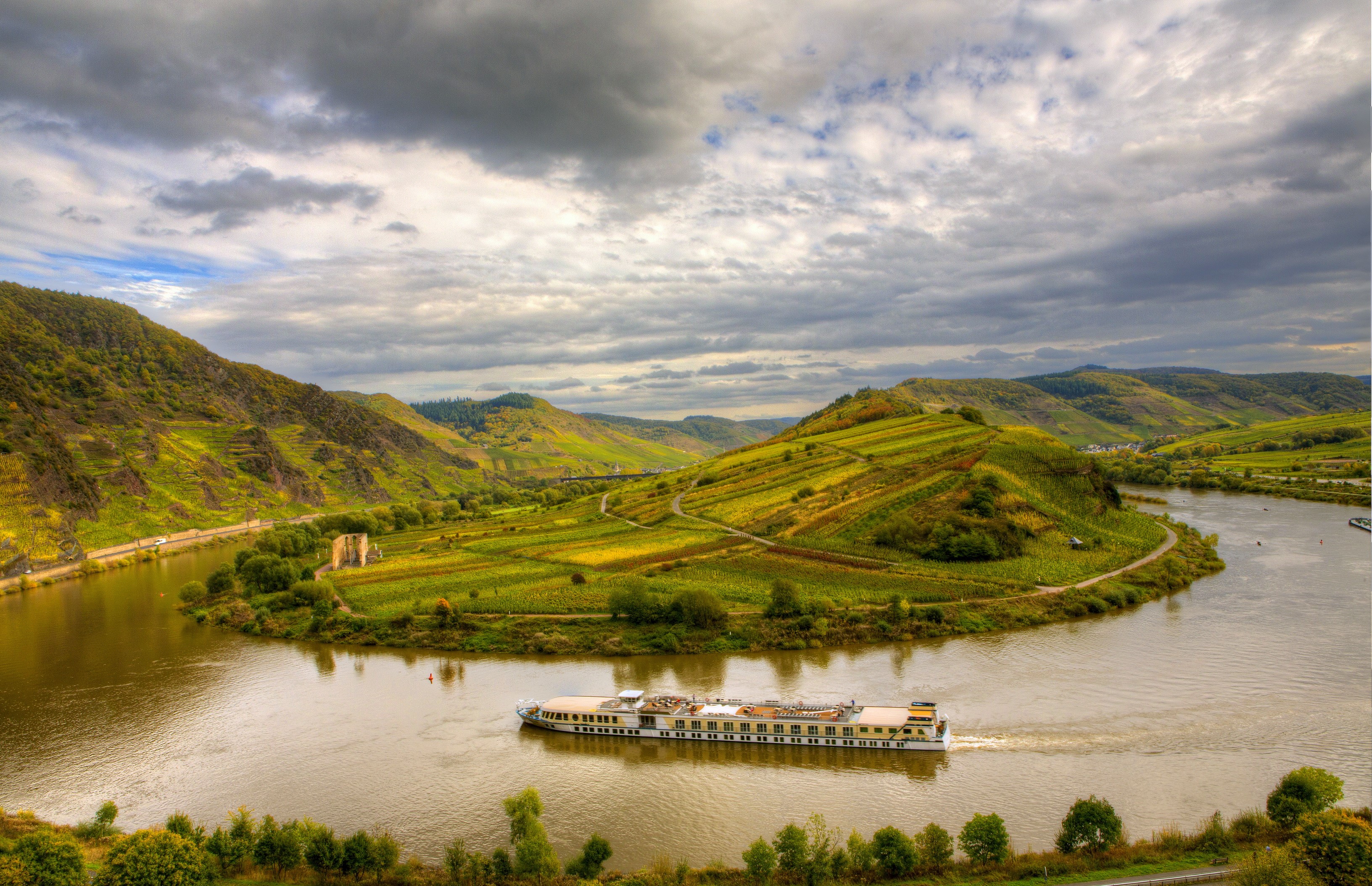 River cruise ship on a winding river surrounded by vineyards in Germany HD Wallpaper