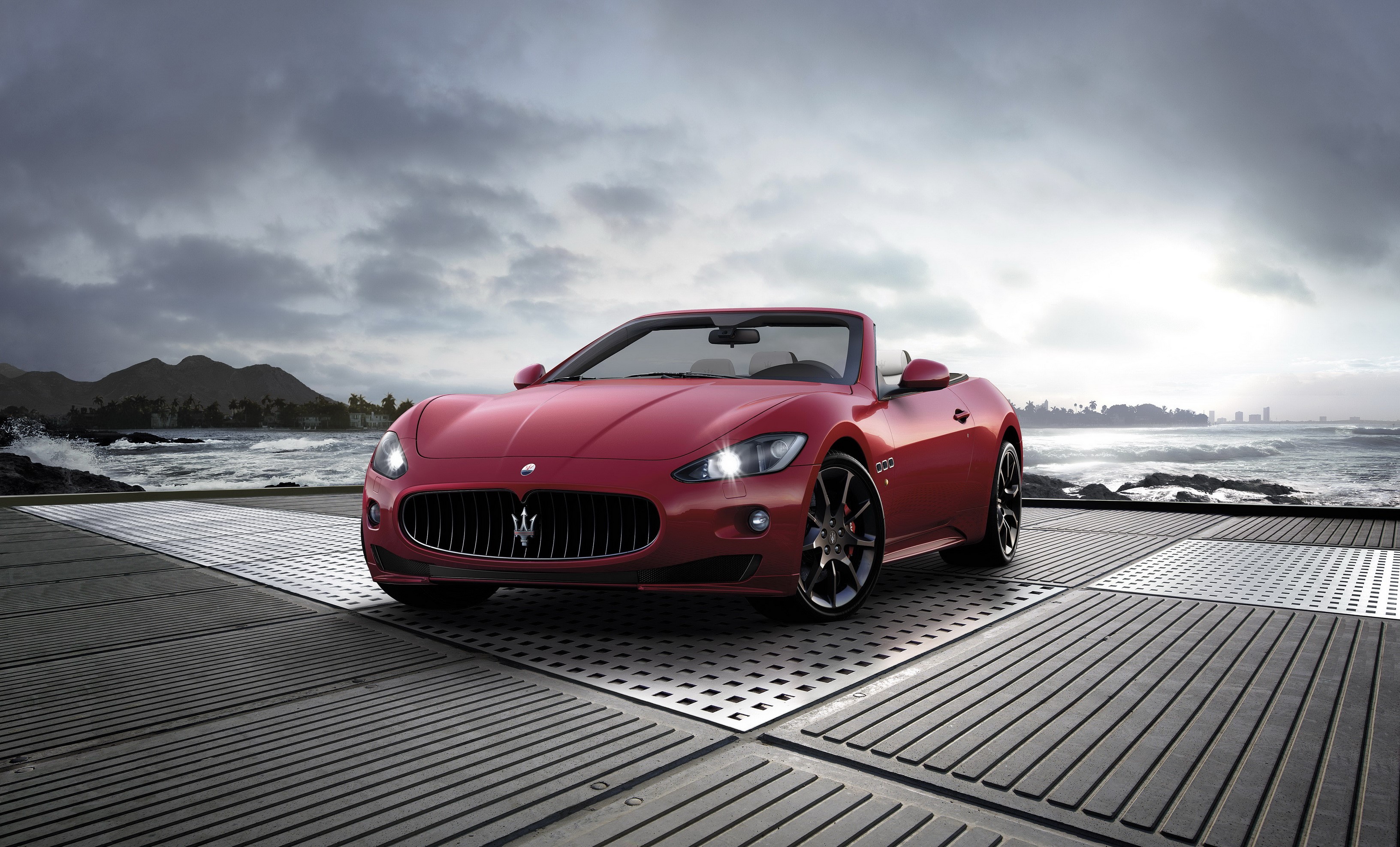 Red Maserati Gran Cabrio Sport convertible on a platform by the ocean HD Wallpaper