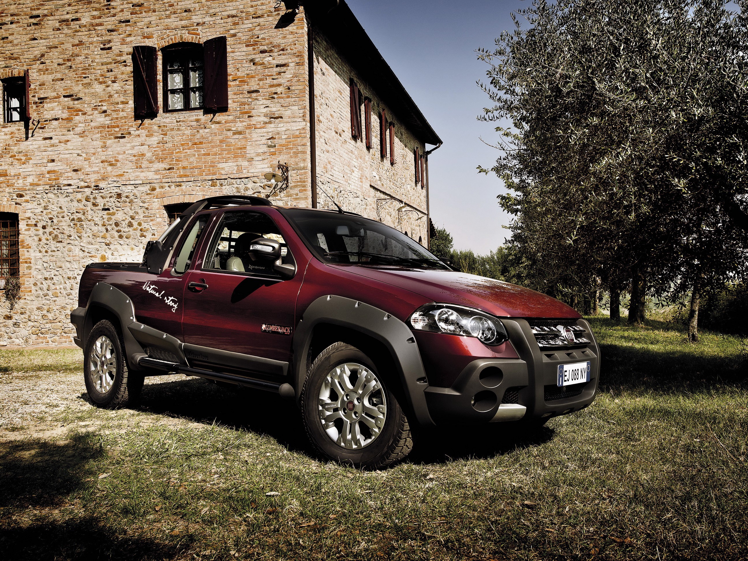 Fiat Strada pickup truck parked near a brick building HD Wallpaper