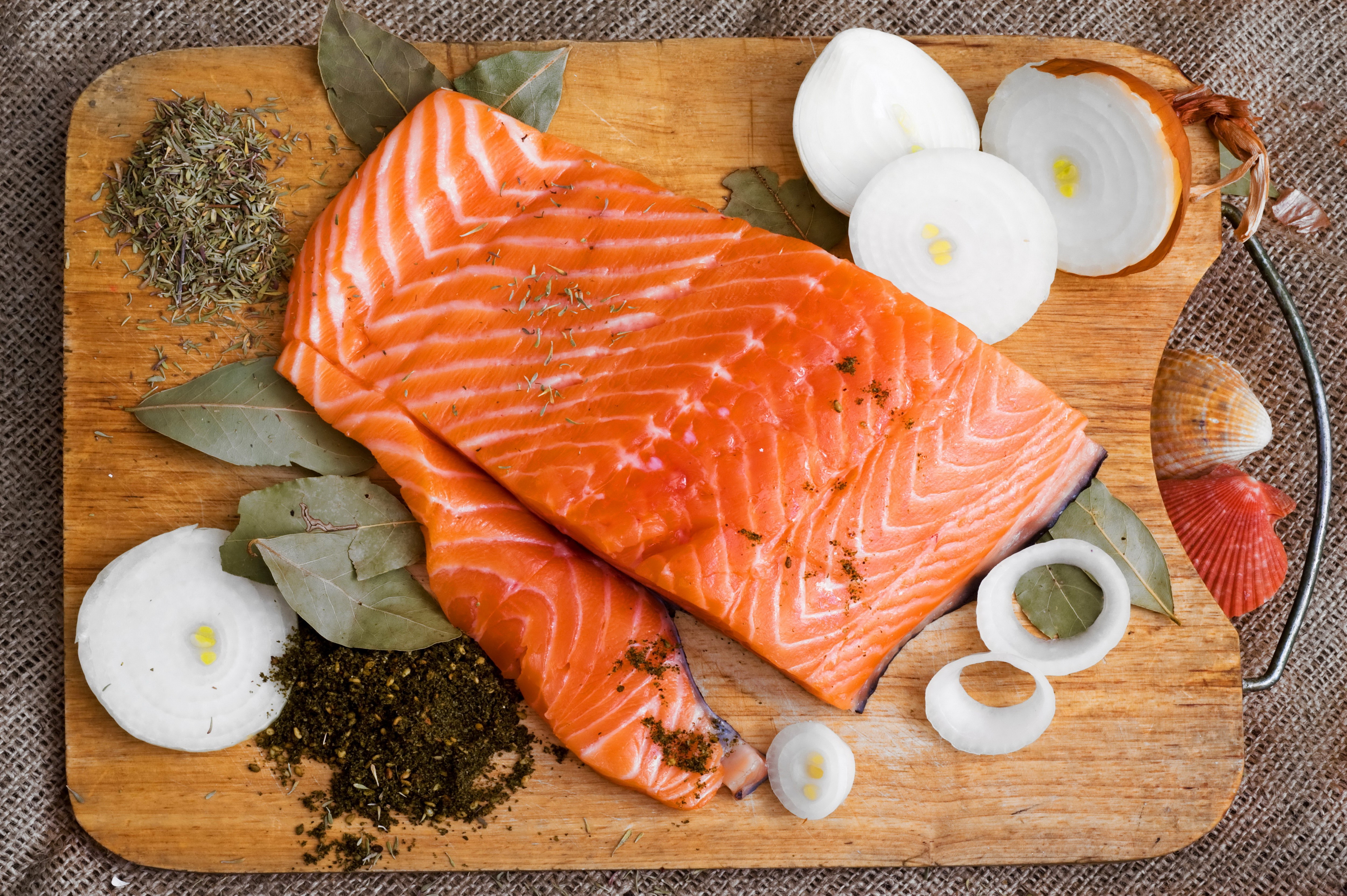 Salmon fillets with onions and herbs on a cutting board HD Wallpaper