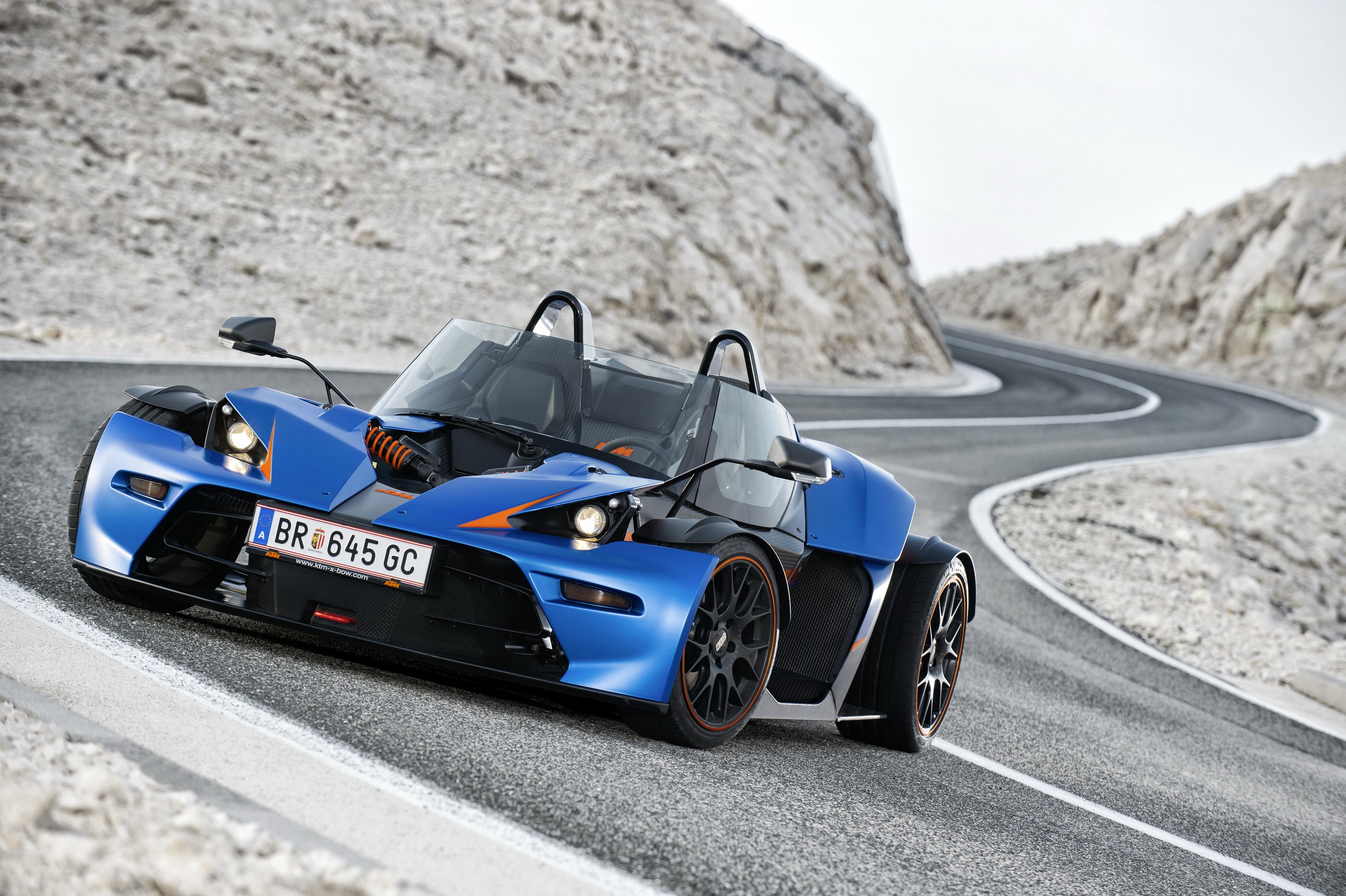 Blue 2013 KTM X-Bow GT on a winding road HD Wallpaper