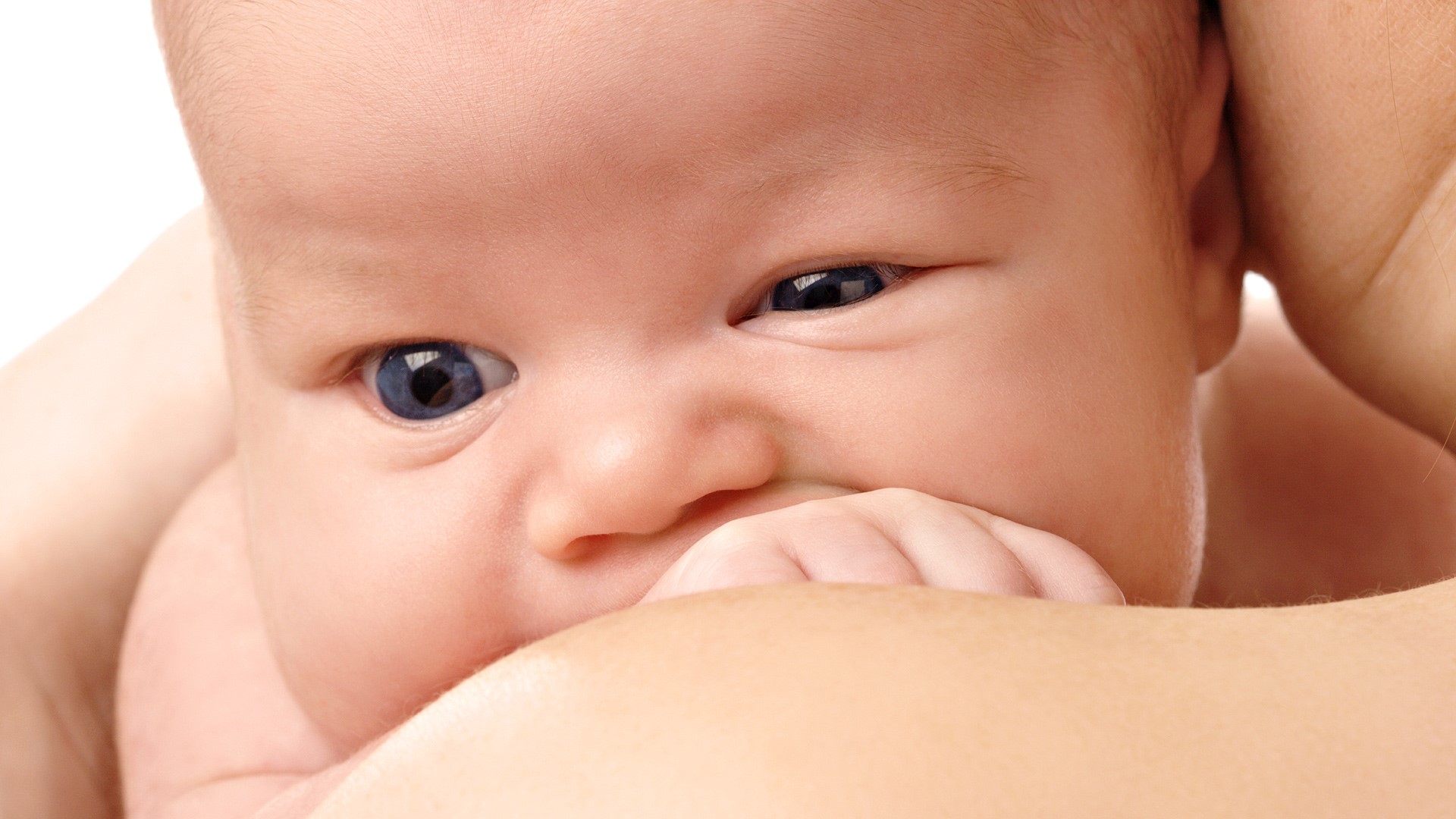 Close-up of a baby's face with blue eyes HD Wallpaper
