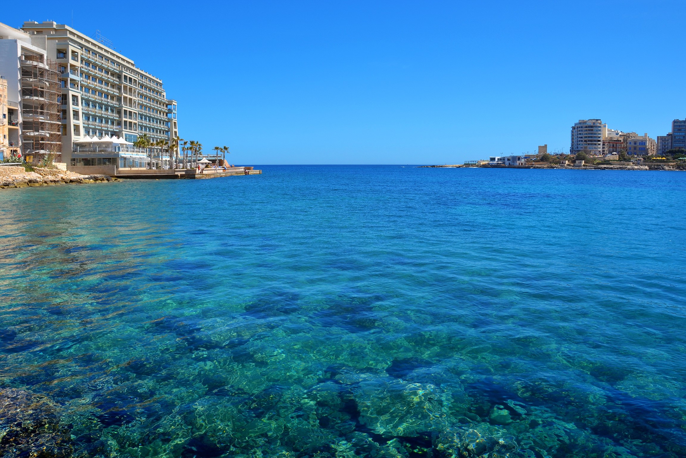 St. Julian's, Malta: Coastal view with clear blue sea and buildings HD Wallpaper