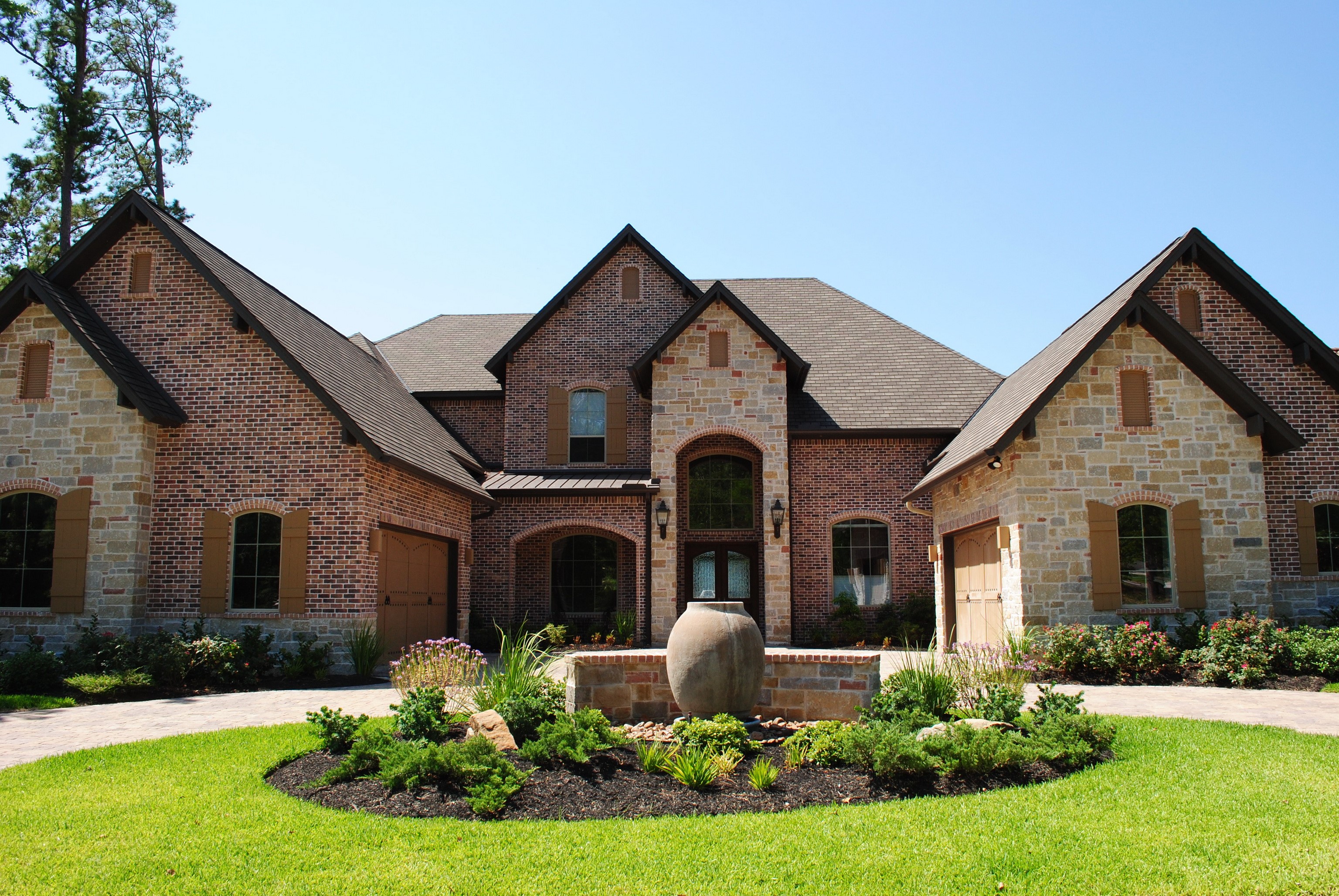Brick and stone mansion with circular driveway and fountain HD Wallpaper