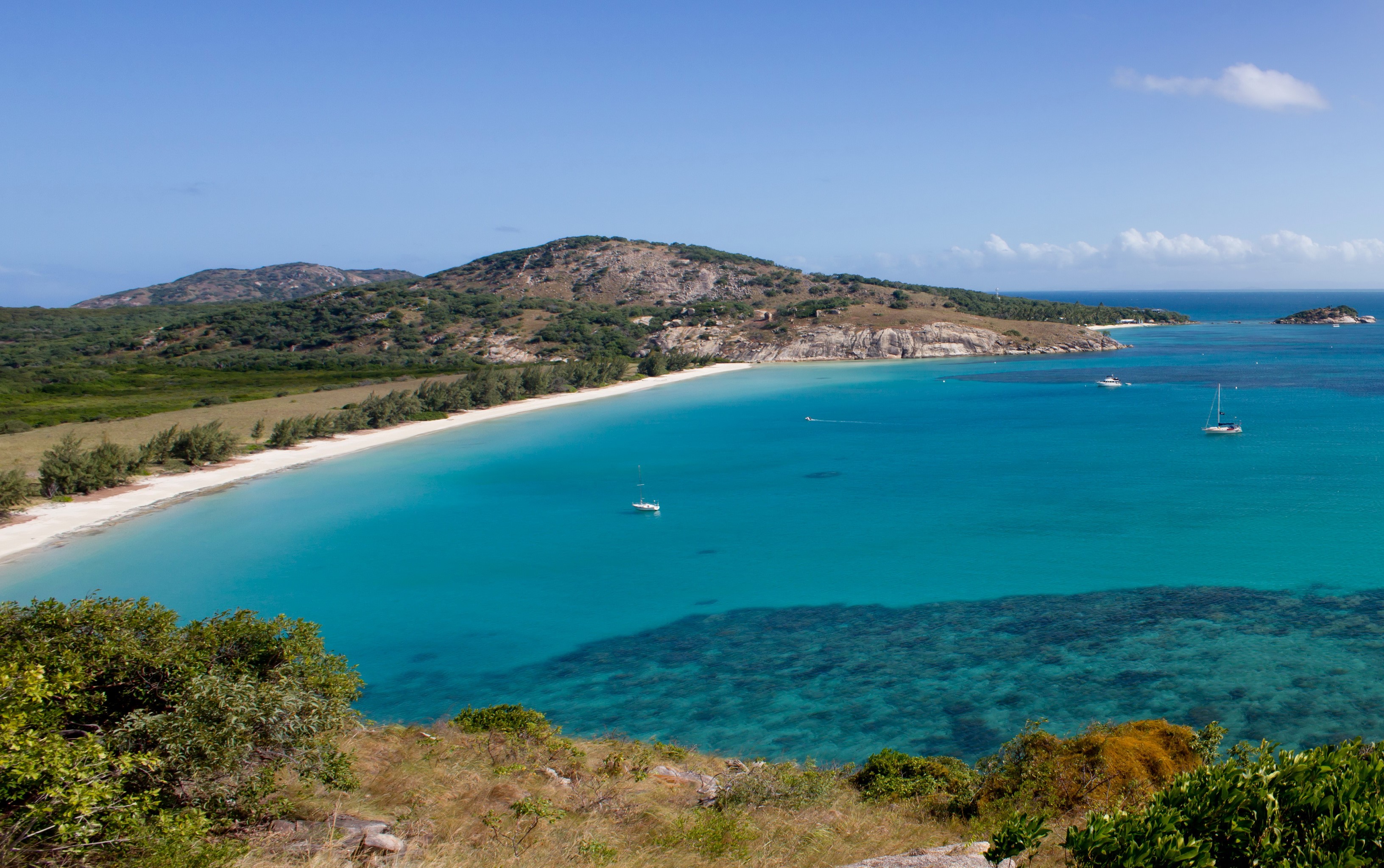 Turquoise bay with white sand beach and green hills HD Wallpaper