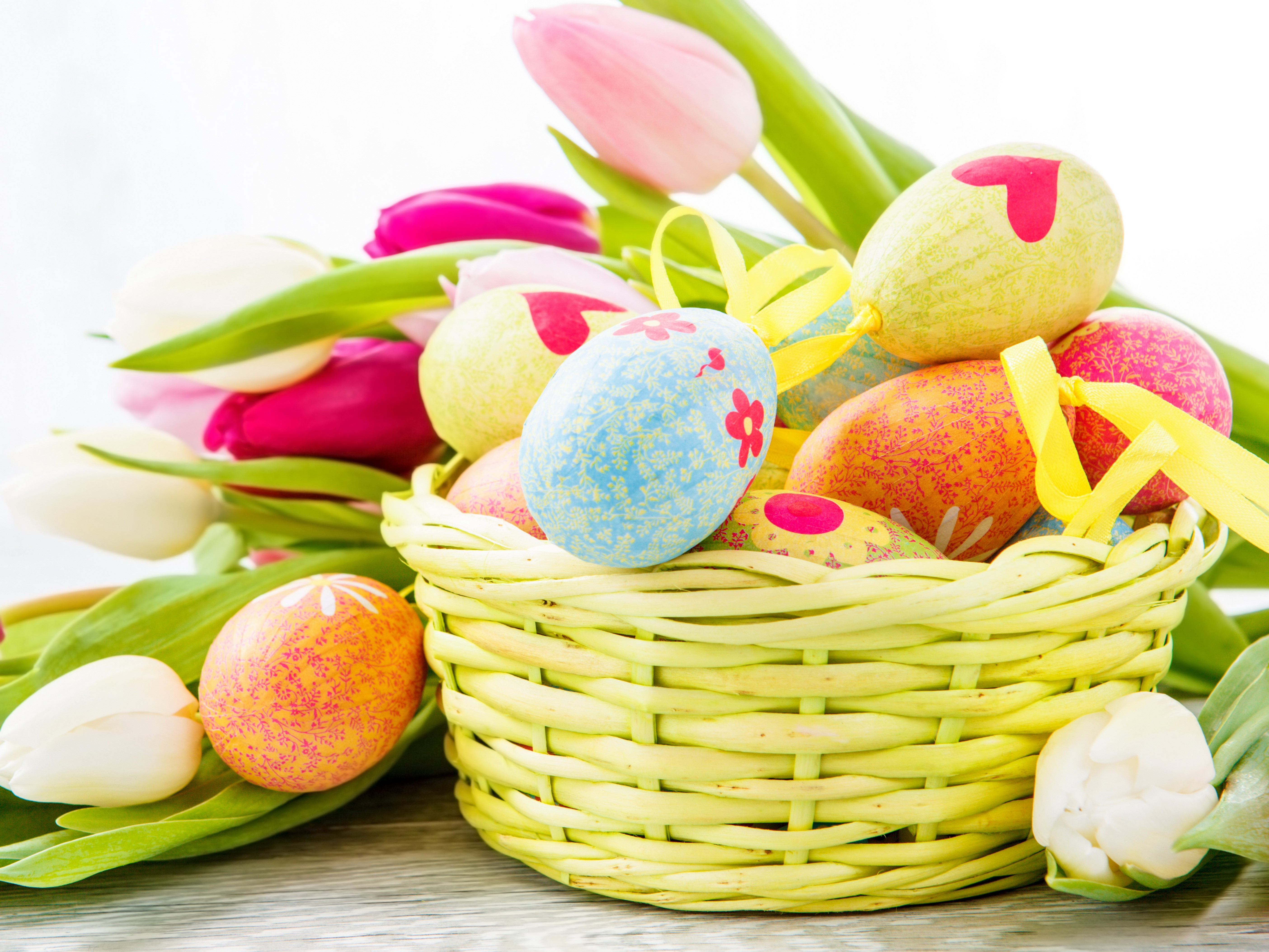 Easter eggs in a wicker basket with tulips HD Wallpaper