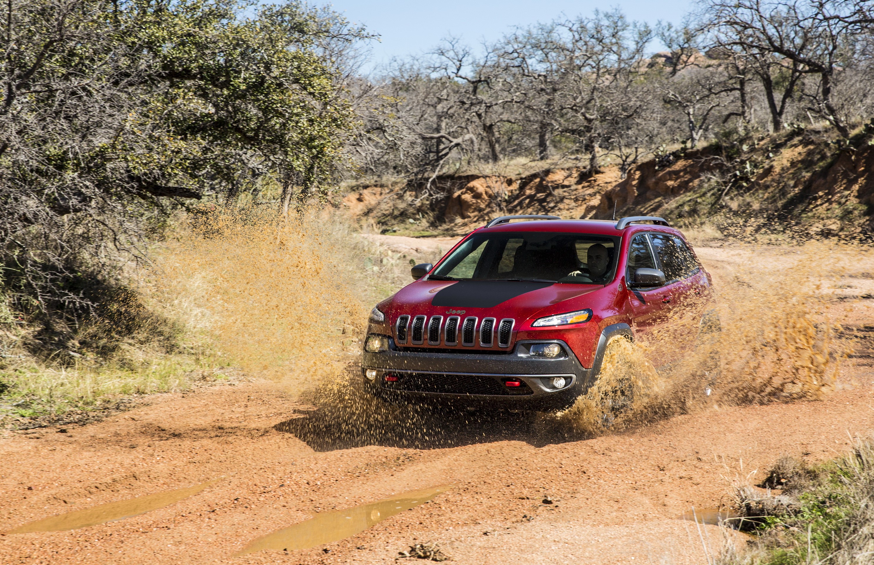Red Jeep Cherokee Trailhawk driving through mud HD Wallpaper