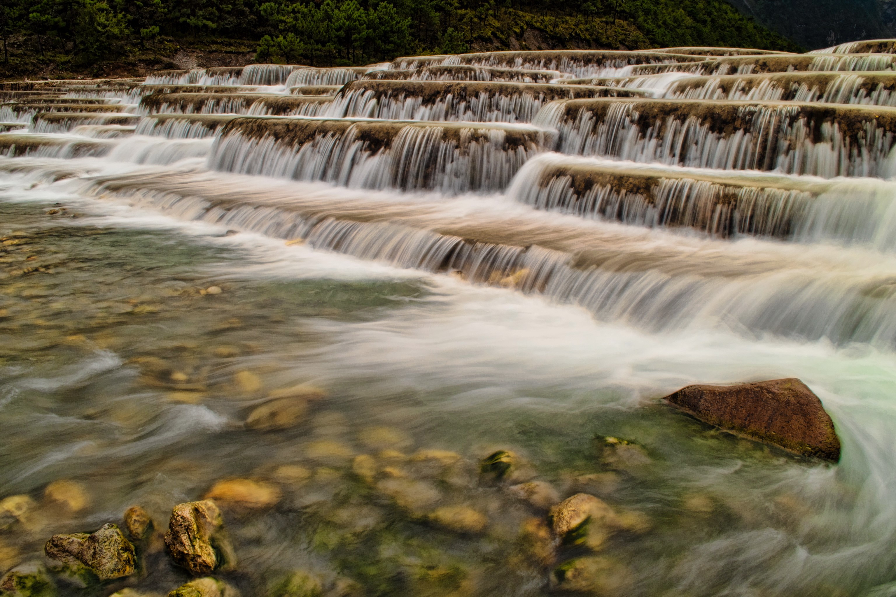 Terraced waterfalls cascading over rocks in Lijiang, China HD Wallpaper
