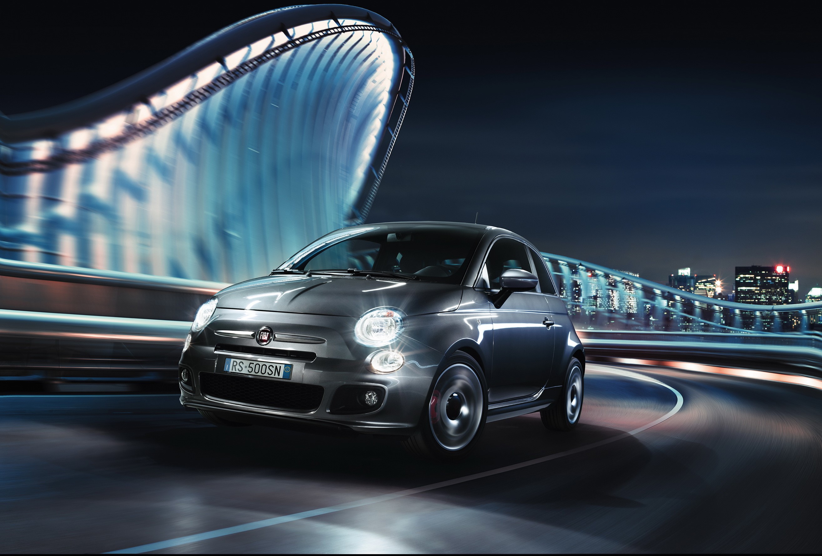 Fiat 500S driving on a city road at night HD Wallpaper