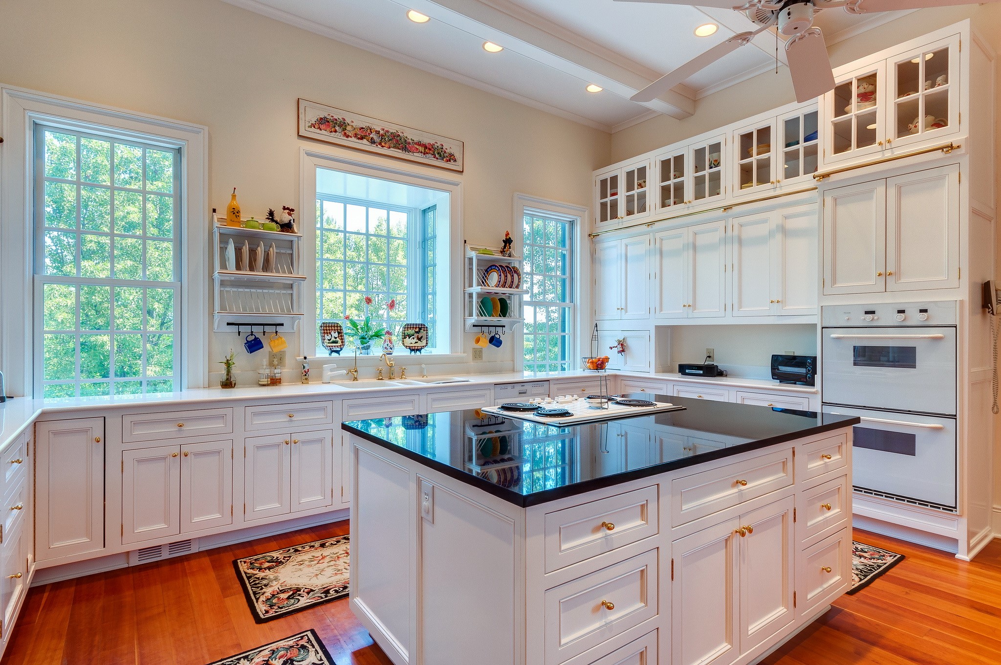 Kitchen with white cabinets and black island HD Wallpaper